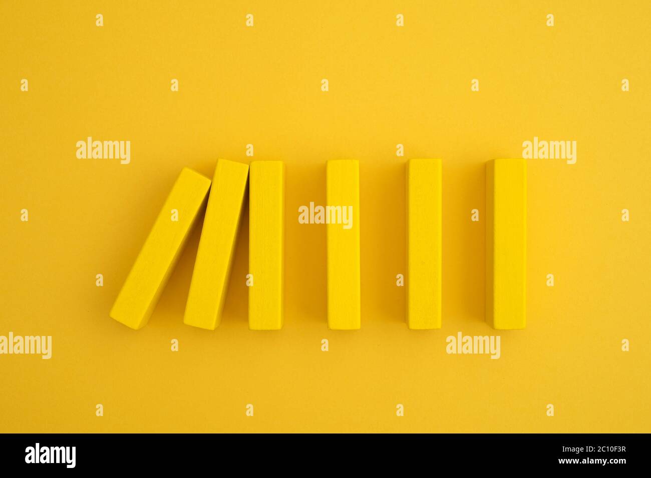 Gelber Domino-Block beginnt zu fallen Stockfoto