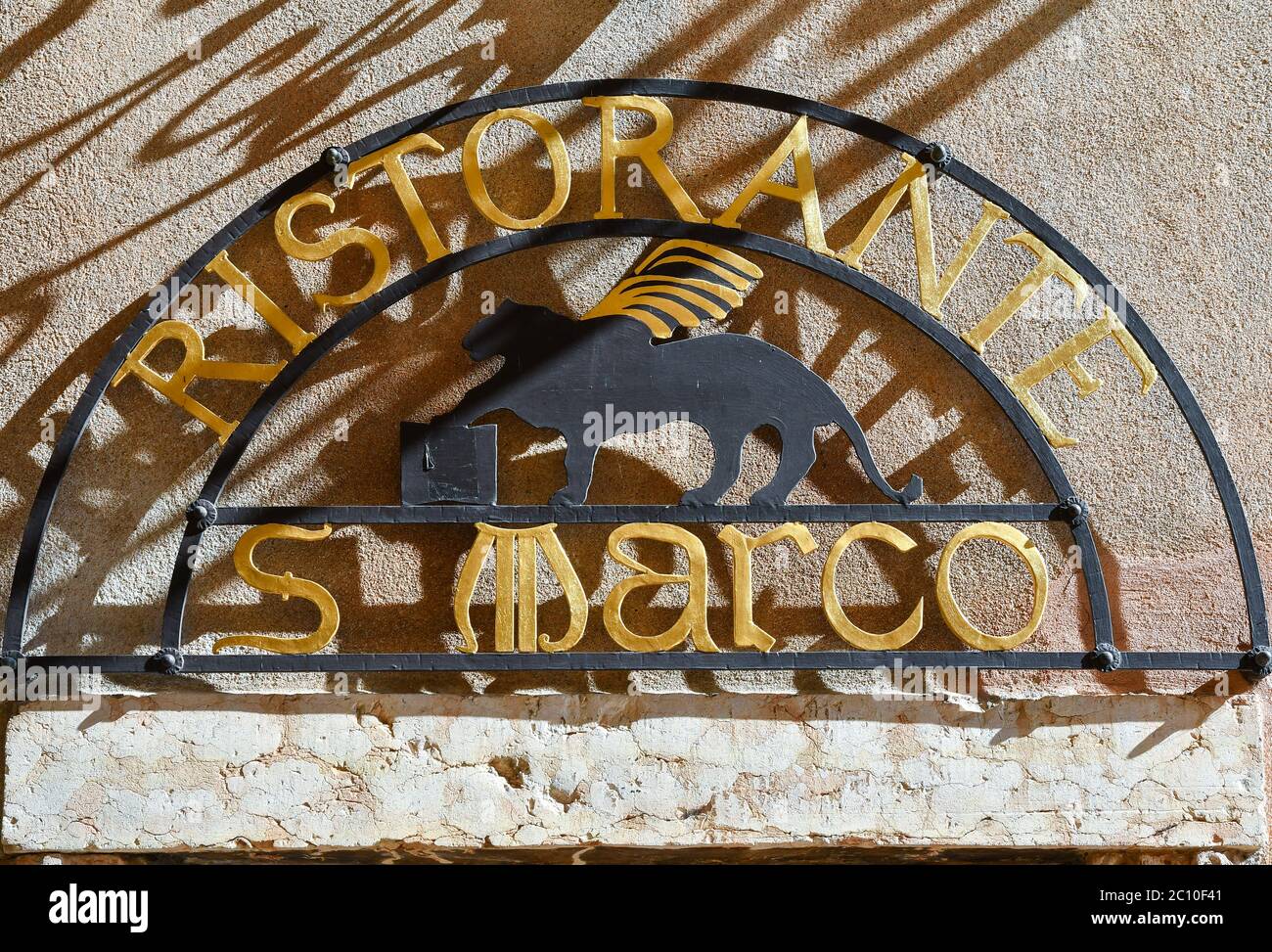 Nahaufnahme des Metallzeichens eines Restaurants mit dem geflügelten Löwen des Hl. Markus, Symbol der Stadt Venedig an einer alten Mauer, Lazise, Verona, Venetien, Italien Stockfoto