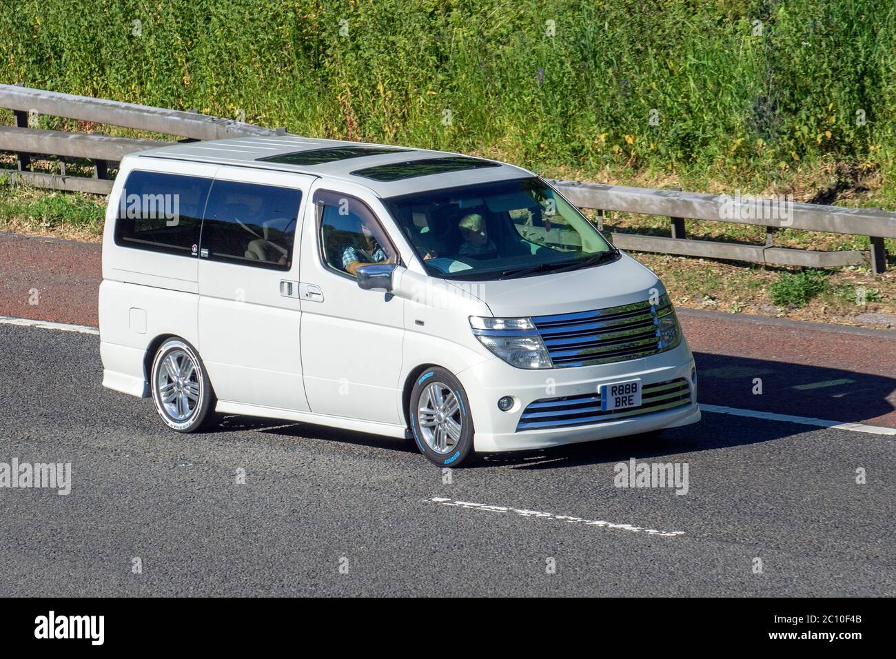 2002 weiße Nissan People Carrier; Fahrzeug Verkehr Fahrzeuge, Autos fahren Fahrzeug auf britischen Straßen, Motoren, Fahren auf der Autobahn M6 Stockfoto