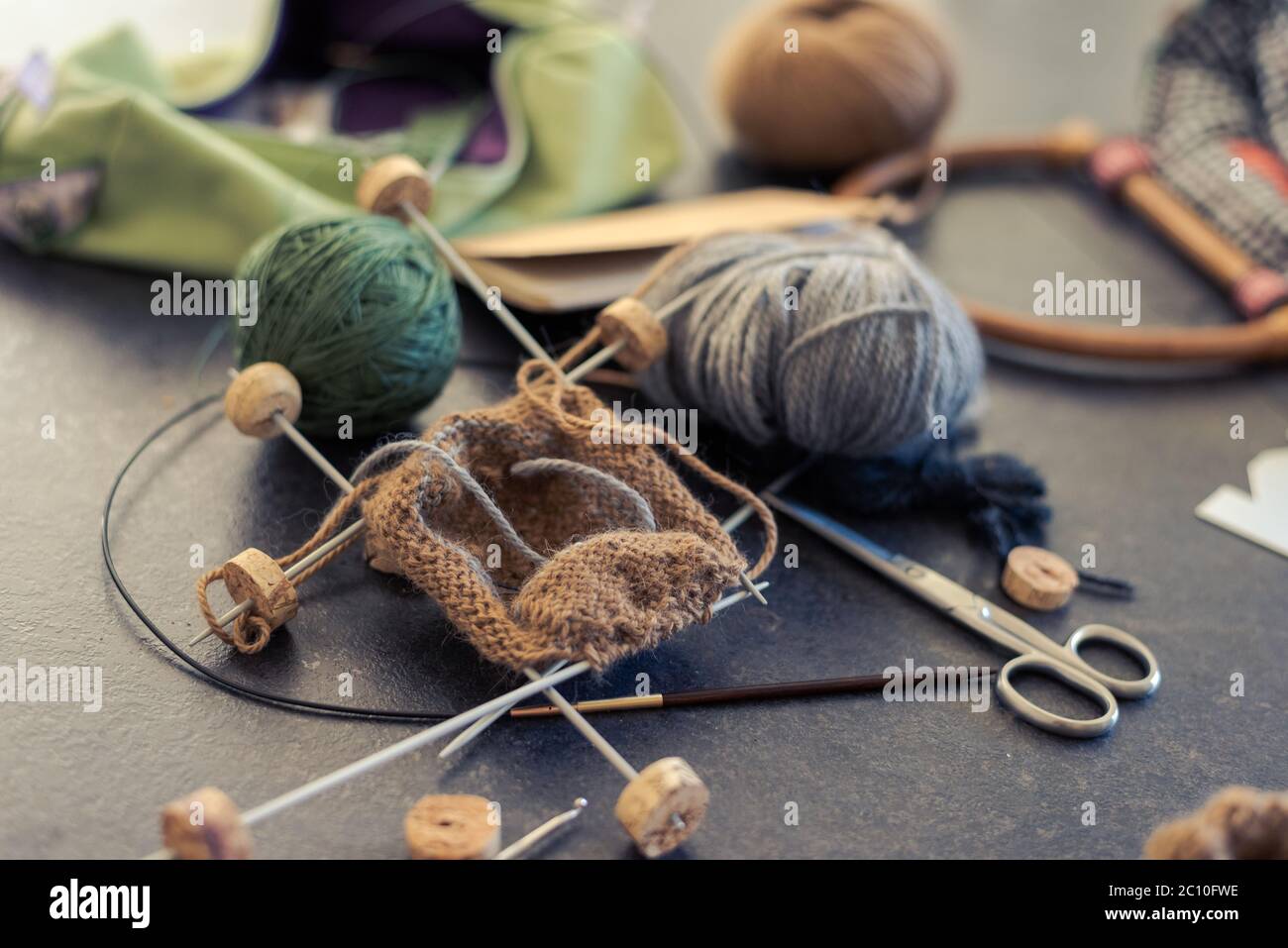 Chaotisch kreatives Chaos auf dem Tisch beim Stricken von Socken Stockfoto