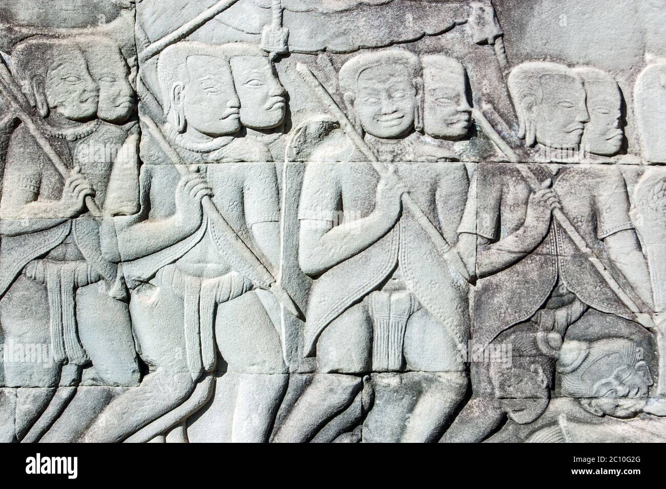 Alte Khmer Bas Relief Schnitzerei zeigt die Khmer Armee in den Kampf gehen. Einige ihrer Kollegen liegen betrunken auf dem Boden. Außenwand von Bayon Stockfoto