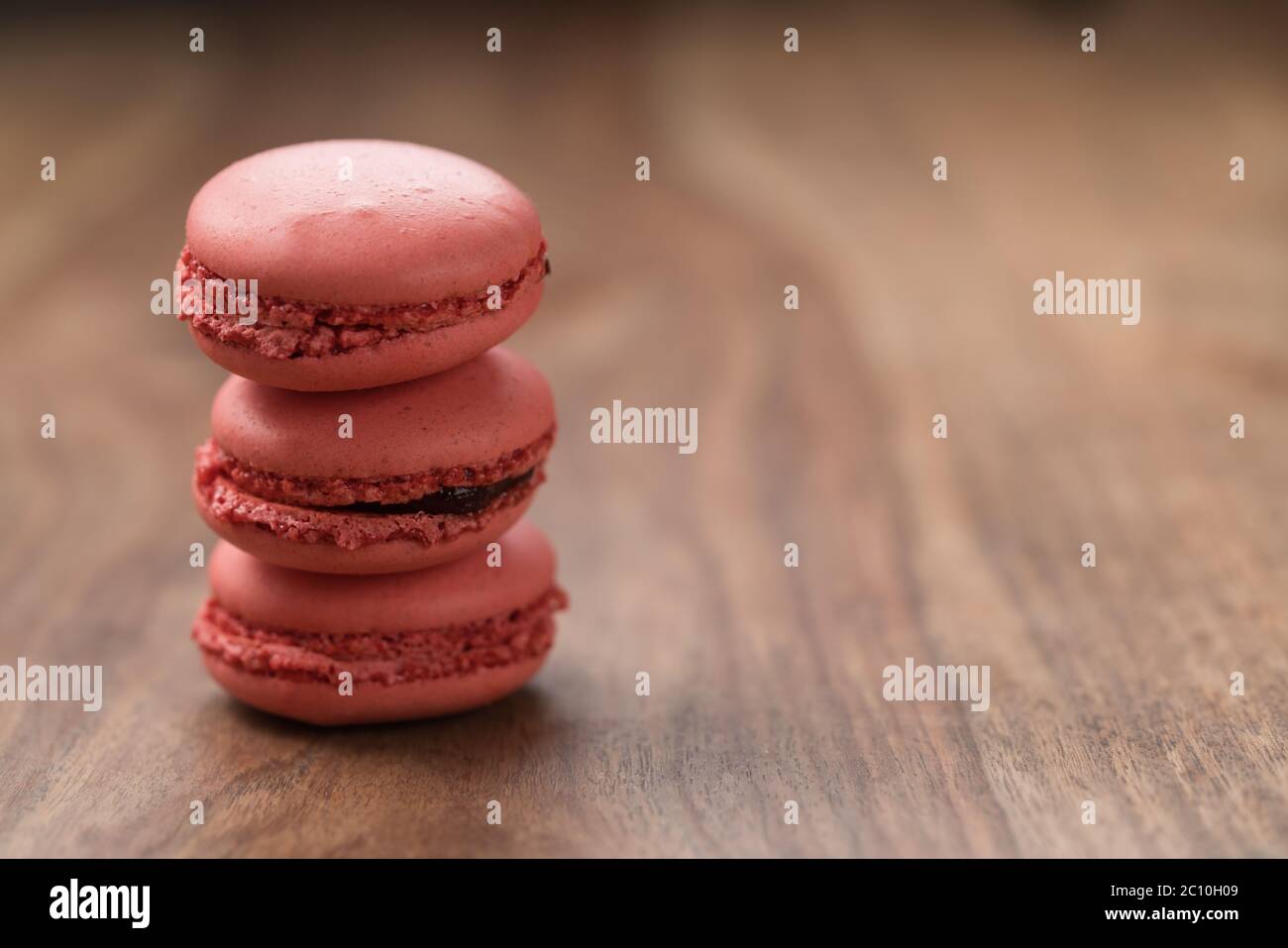 Lebhaft rosa Farbe Macarons auf Holz Hintergrund mit Kopierraum Stockfoto