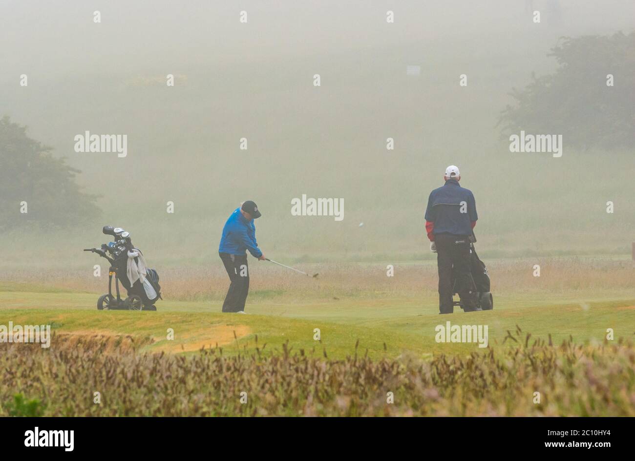 Gullane, East Lothian, Schottland, Großbritannien, 13. Juni 2020. UK Wetter: Eingefleischte Golfer auf dem Golfplatz Gullane spielen trotz des starken dichten Nebels und Nieselregen weiter, was bedeutet, dass das Sehen der Bälle oder der Golfflagge/Pin schwierig ist Stockfoto