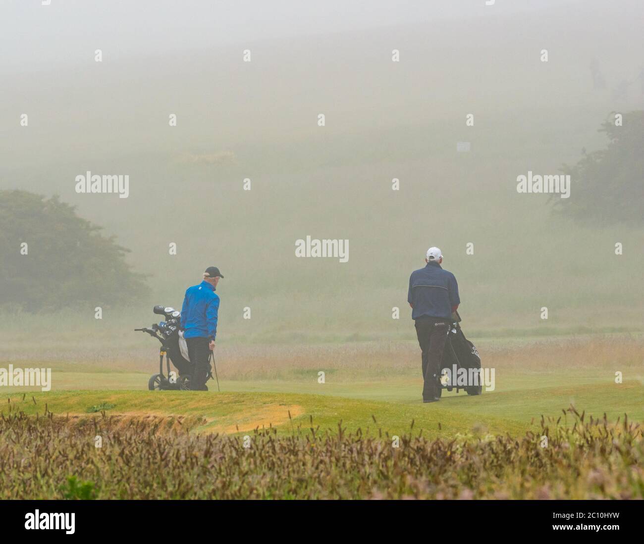 Gullane, East Lothian, Schottland, Großbritannien, 13. Juni 2020. UK Wetter: Eingefleischte Golfer auf dem Golfplatz Gullane spielen trotz des starken dichten Nebels und Nieselregen weiter, was bedeutet, dass das Sehen der Bälle oder der Golfflagge/Pin schwierig ist Stockfoto