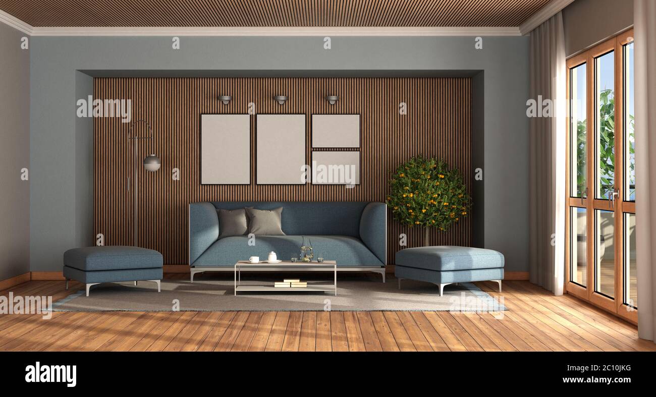 Modernes Wohnzimmer mit elegantem blauem Sofa und Fußhocker gegen Holzwand - 3d-Rendering Stockfoto