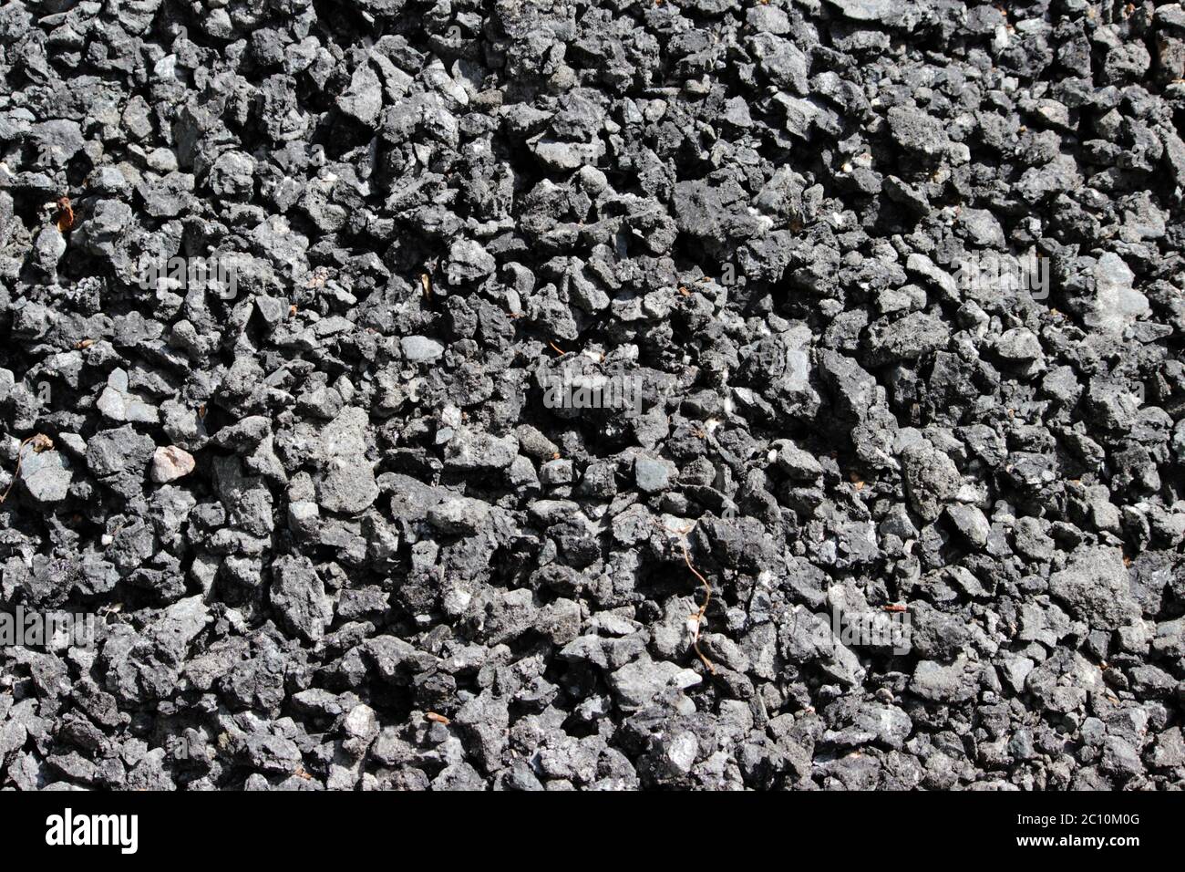 Grobkörnige Textur eines silbrig schwarzen Schleifmaterials aus Asphaltsteinen für Tapeten Stockfoto