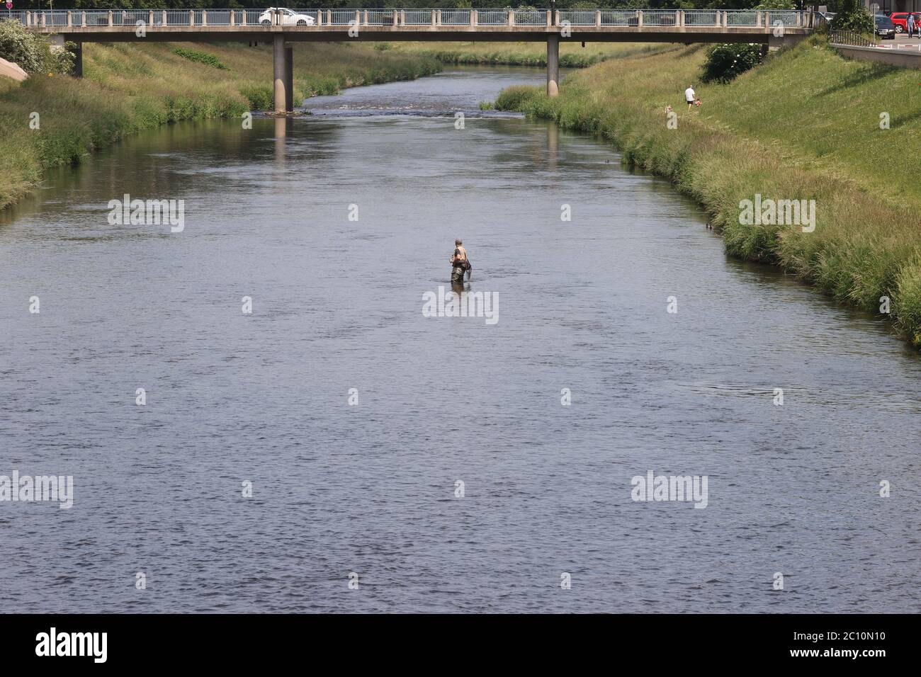 Gera, Deutschland. Juni 2020. Ein Fischer steht im Fluss White Elster. Auch für die nächsten Tage wird das Sommerwetter vorhergesagt. Kredit: Bodo Schackow/dpa-zentralbild/dpa/Alamy Live Nachrichten Stockfoto