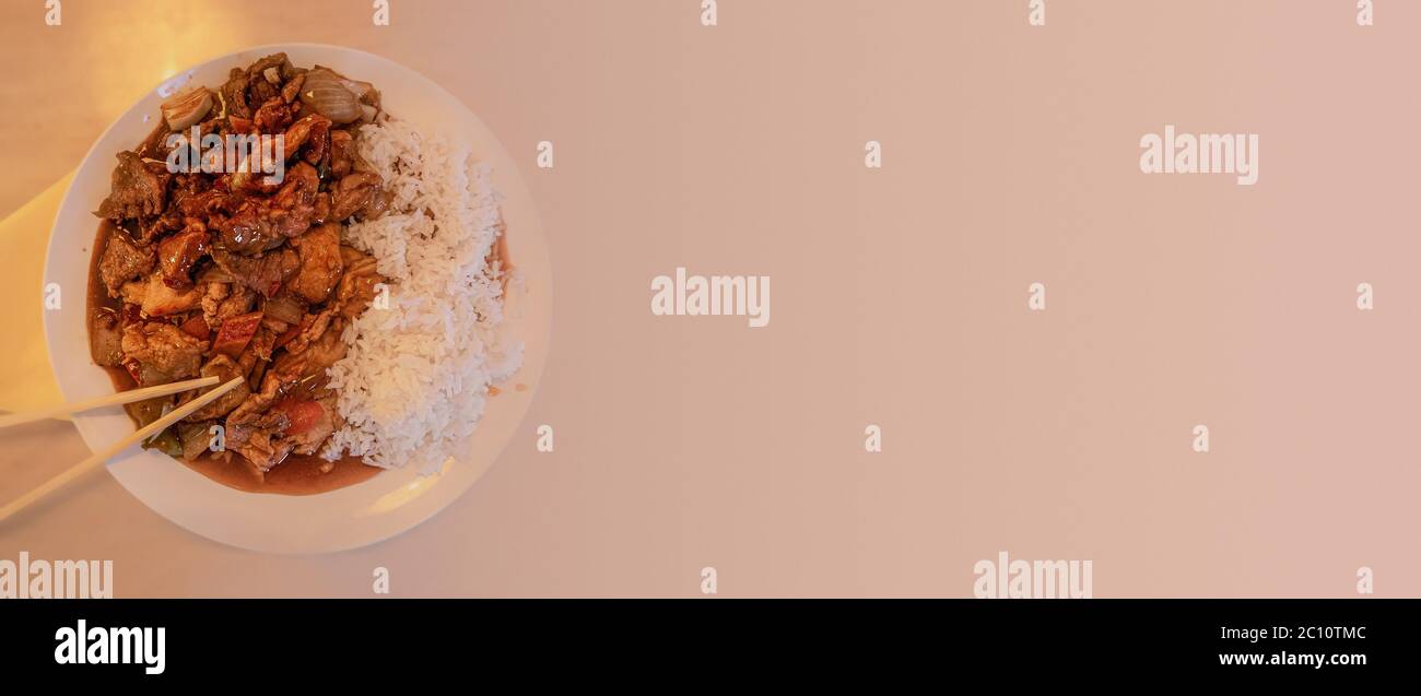 Banner mit asiatischem Fast-Food-Stil, gebratenes Huhn mit Gemüse, Reis und Holzchelchstäbchen mit Platz für Text Stockfoto