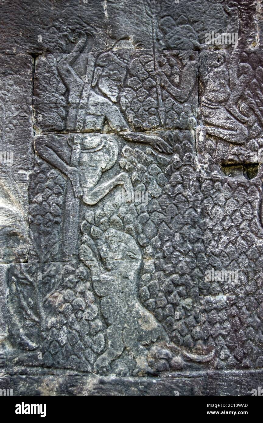 Alte Khmer Bas Relief Schnitzerei von zwei Männern versteckt Bäume, nachdem sie von einem Tiger verfolgt. Mauer des Bayon-Tempels, Angkor Thom, Siem Reap, Kambodscha. Stockfoto