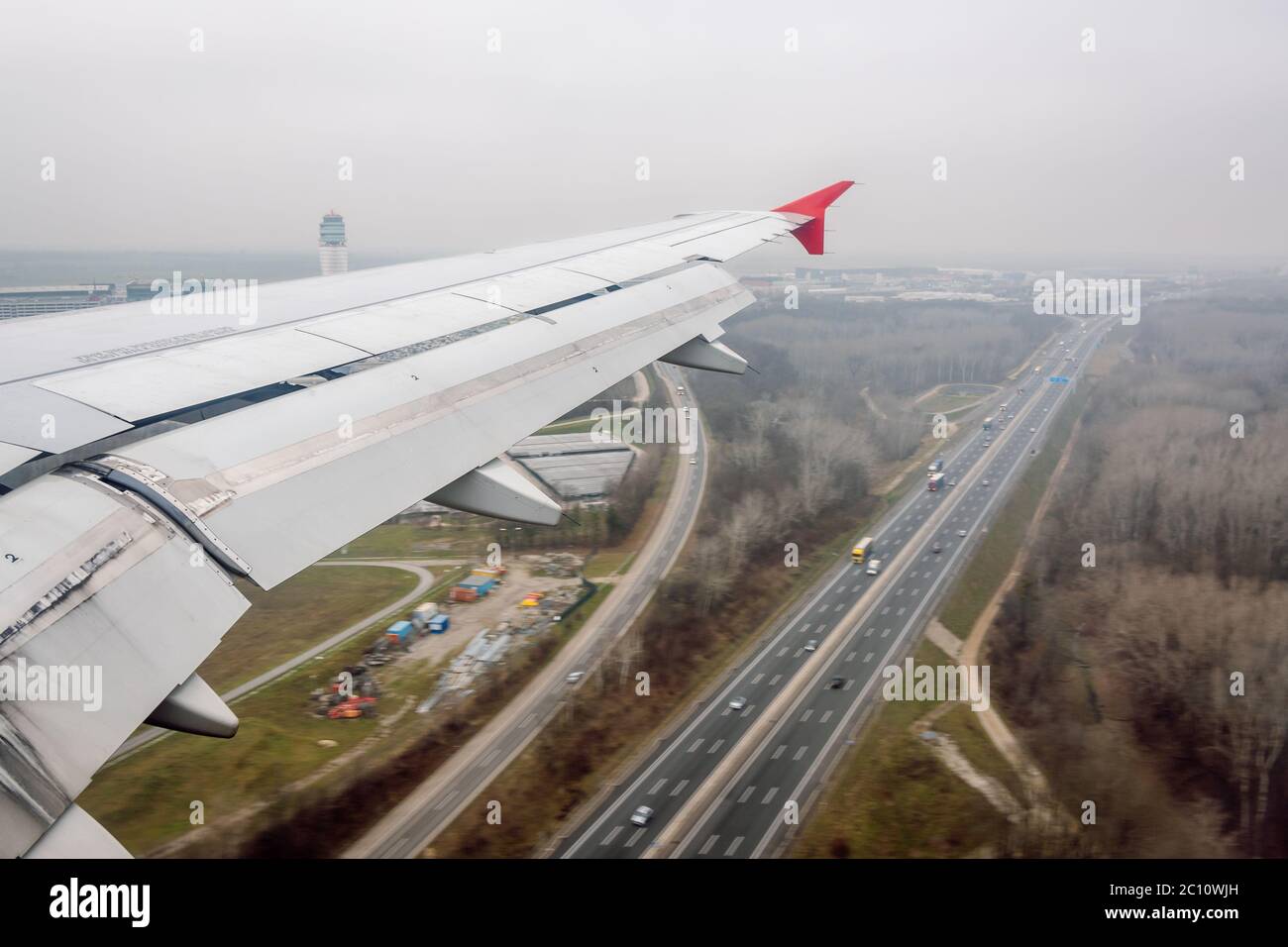 Flugzeugflügel mit abgesenkten Landeklappen, um die Geschwindigkeit beim Anflug auf den Flughafen Wien zu verringern. Stockfoto