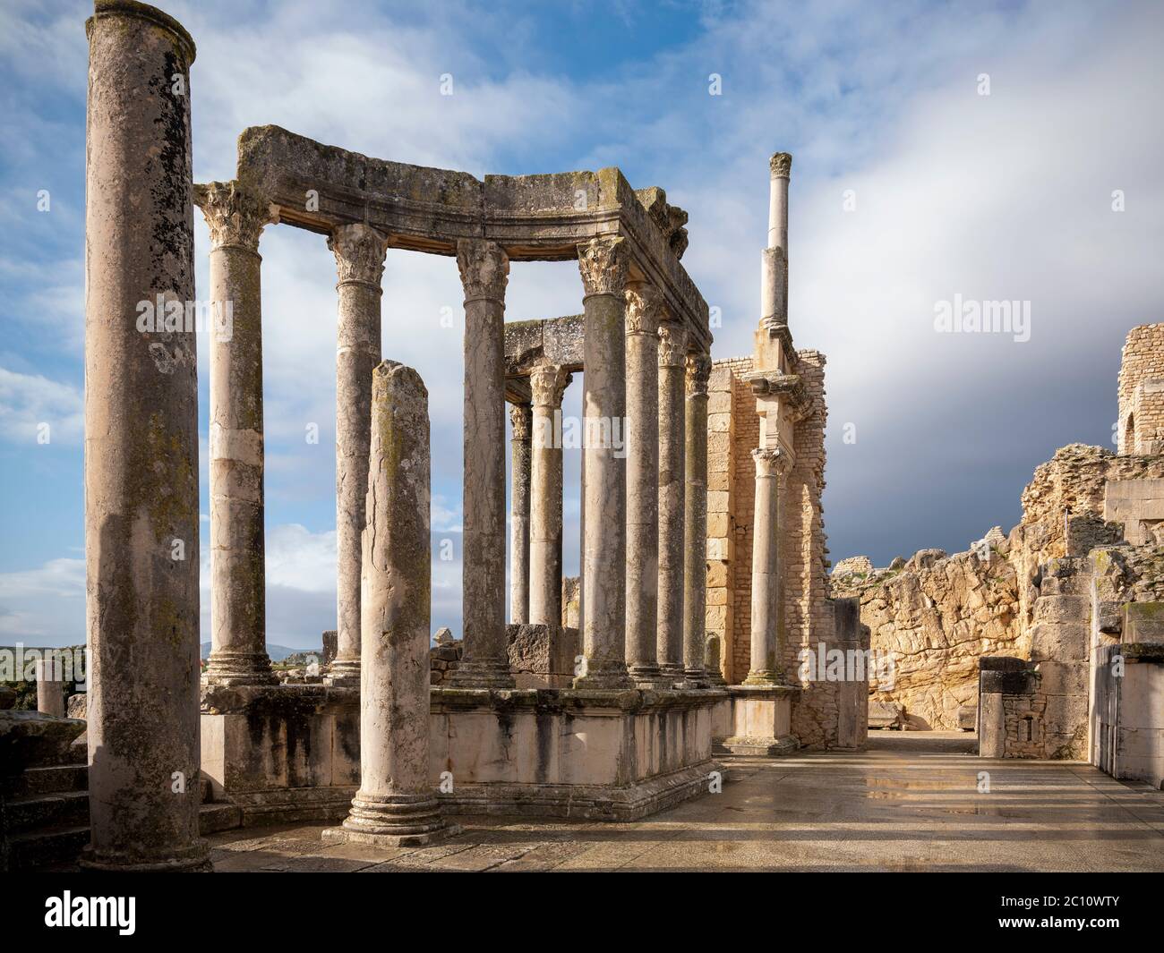 Die antike römische archäologische Stätte von Dougga (Thugga), Tunesien, mit dramatischen Säulen am Eingang zum gut erhaltenen Amphitheater Stockfoto