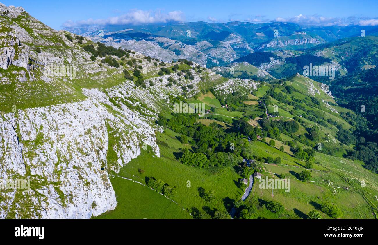 Frühlingslandschaft von Bergen, Wiesen von Mähen und Hütten pasiegas in der Nähe im Valle del Miera, Kantabrien, Spanien, Europa Stockfoto