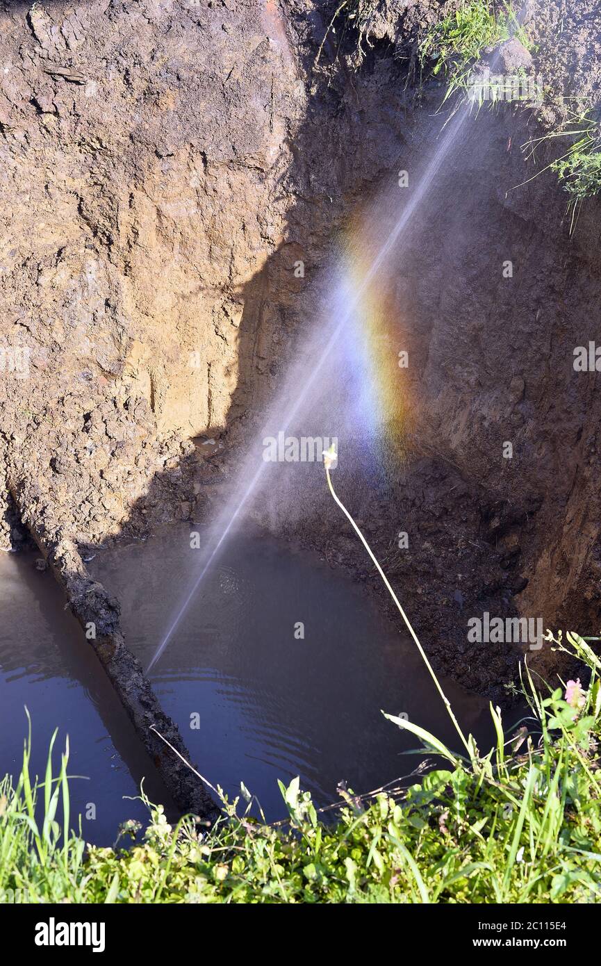 Der Wasserstrahl in Form von Leckagen in der beschädigten Metallleitung am Produktionsstandort Stockfoto