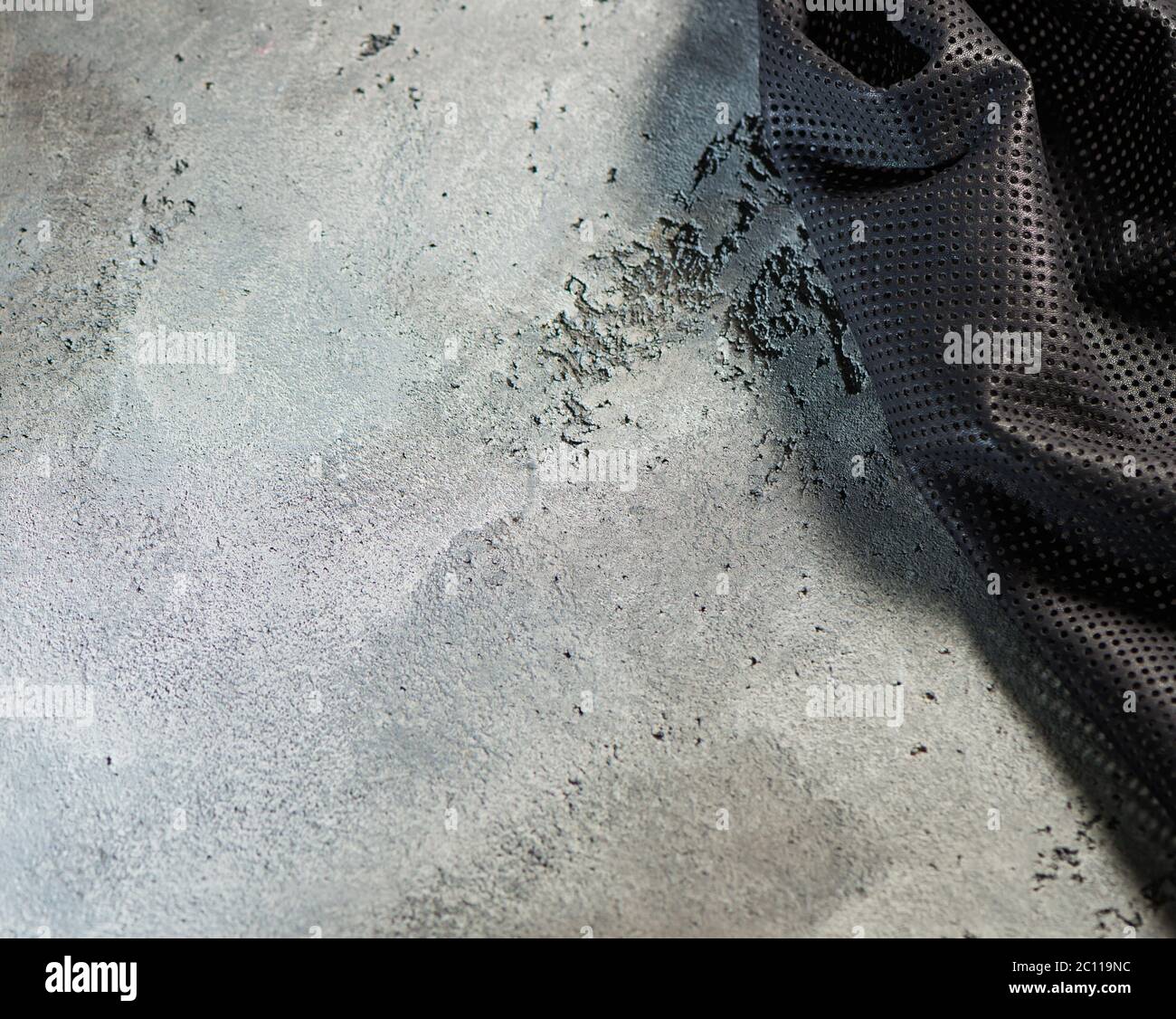 Stück aus schwarzem Stoff strukturierte Oberfläche über grauen Zement Boden Hintergrund Stockfoto