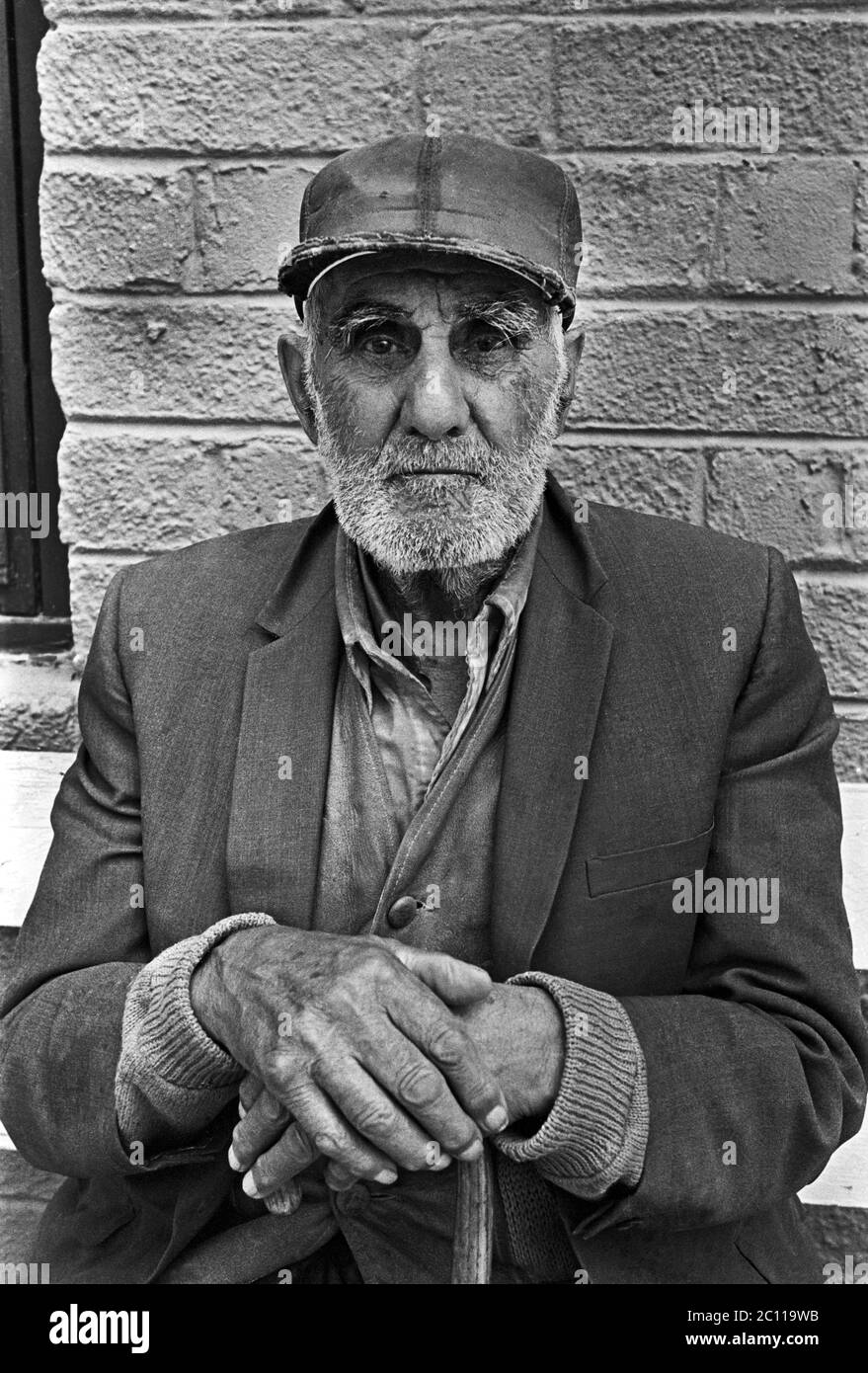 Porträt eines älteren hispanischen Mannes mit Bart auf einer Bank mit einem Stock sitzend, in Santa Fe, New Mexico, um 1973. Stockfoto