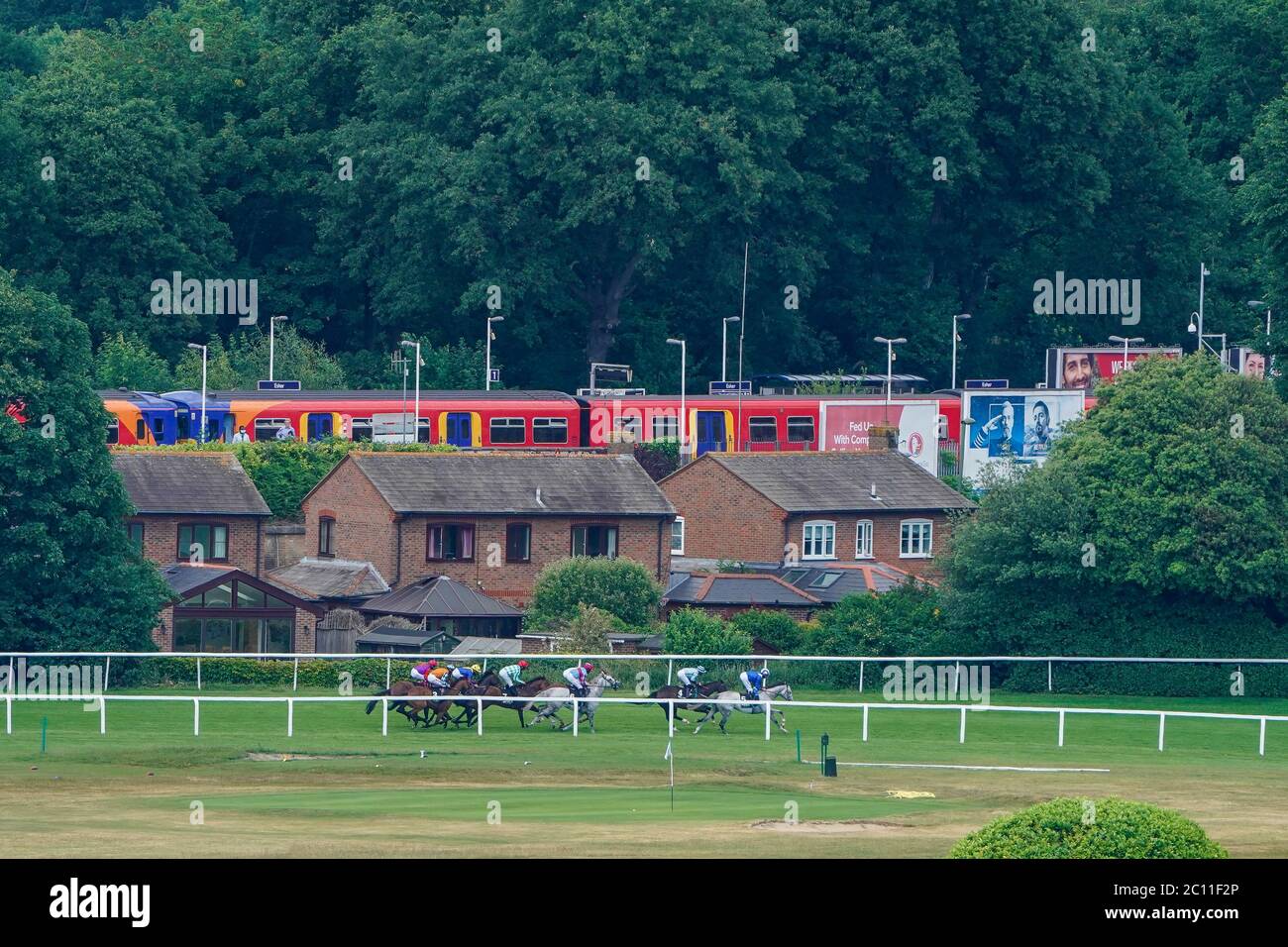 Eine allgemeine Ansicht, wie Läufer Rennen vorbei Esher Station in der Claygate Handicap auf Sandown Park Racecourse. Stockfoto