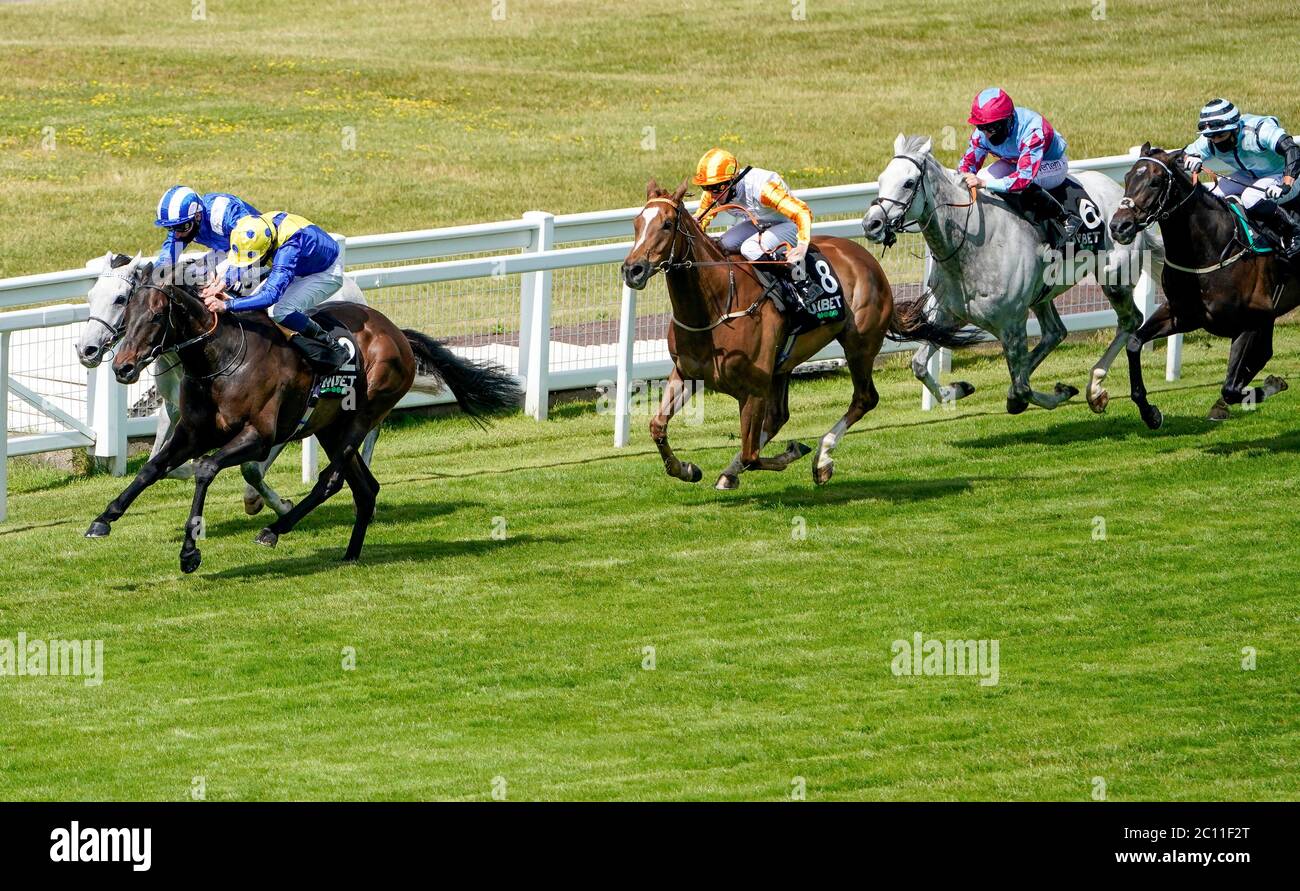 Solid Stone von William Buick (gelbe und blaue Seide) gewinnt das Claygate Handicap auf der Sandown Park Racecourse. Stockfoto