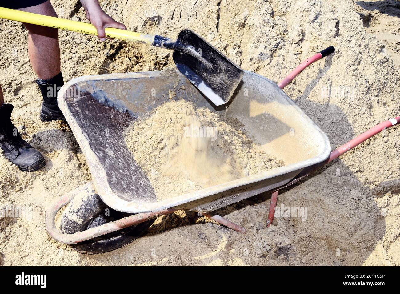 Arbeitsschiff Schaufel Sand in der Bau-LKW zu transportieren Arbeitsschiff Schaufel Sand in der Bau-LKW zu transportieren Stockfoto