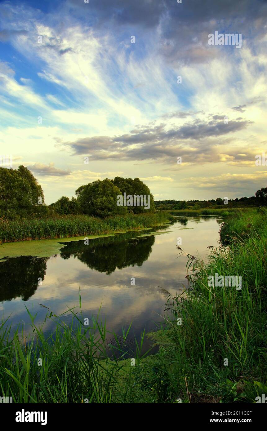 Sommerlandschaft mit dem Himmel und Wolken, die sich im Fluss spiegeln Stockfoto