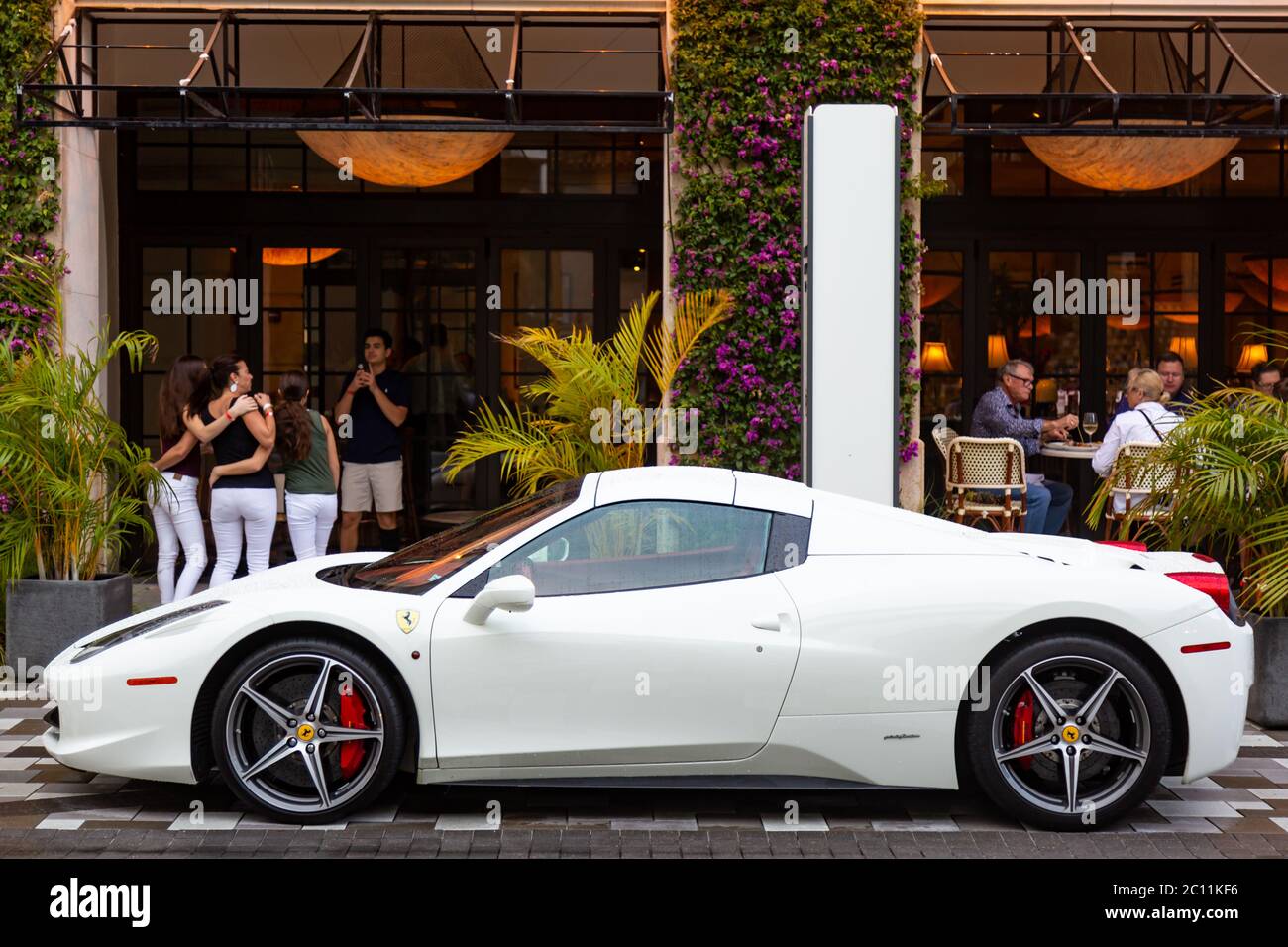 Ein exotischer weißer Sportwagen Ferarri 458 Spider sitzt vor dem trendigen Brio Tuscan Grille am Rosemary's Square in West Palm Beach, Florida, USA. Stockfoto