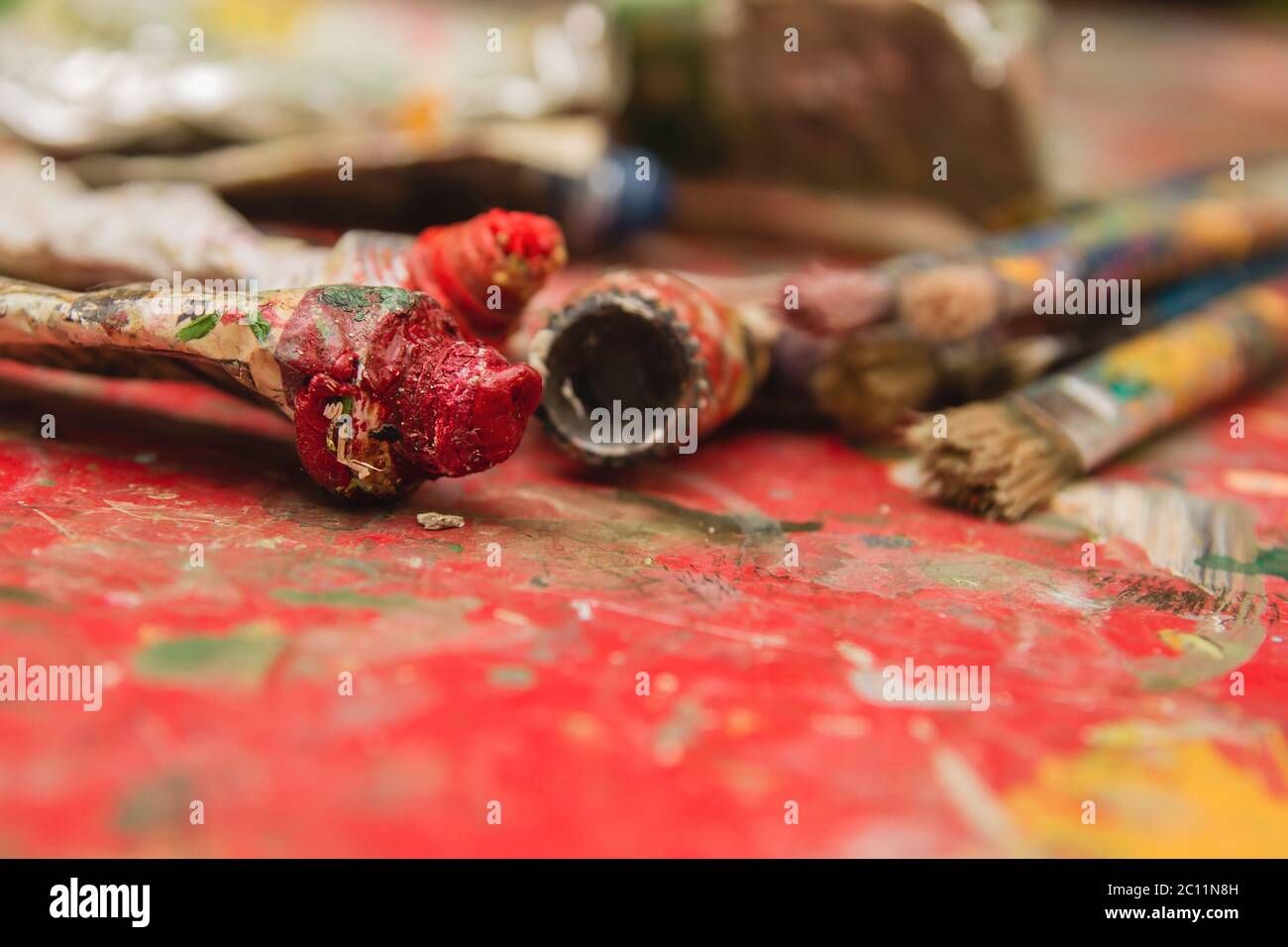 Öllackierrohre und Pinsel auf spritzgespritztem Tisch Stockfoto