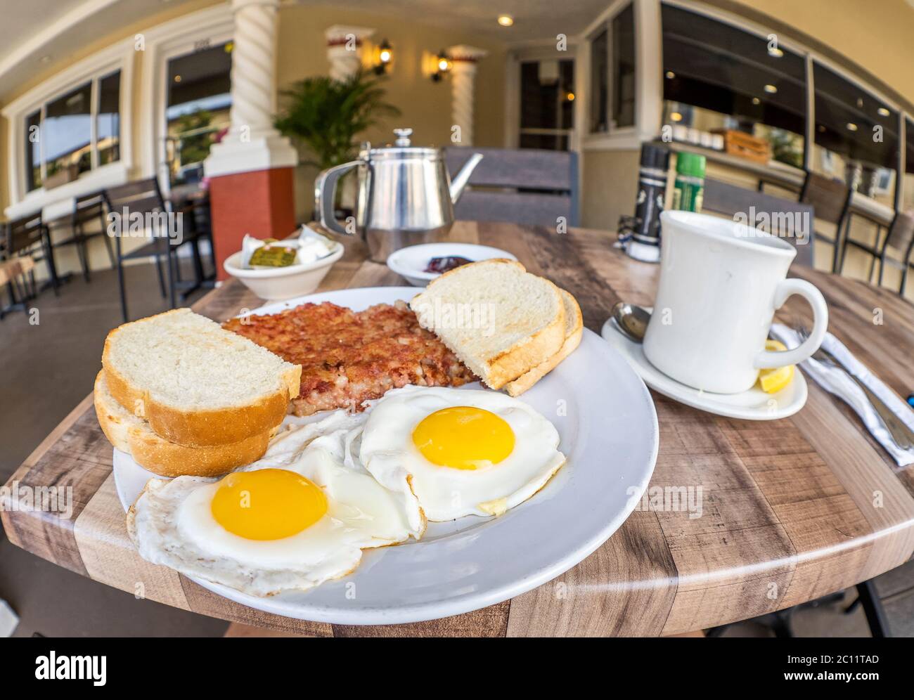 Nahaufnahme des Frühstücksplattes mit Rinderhasch, Eiern und Toast mit Fischaugenobjektiv Stockfoto