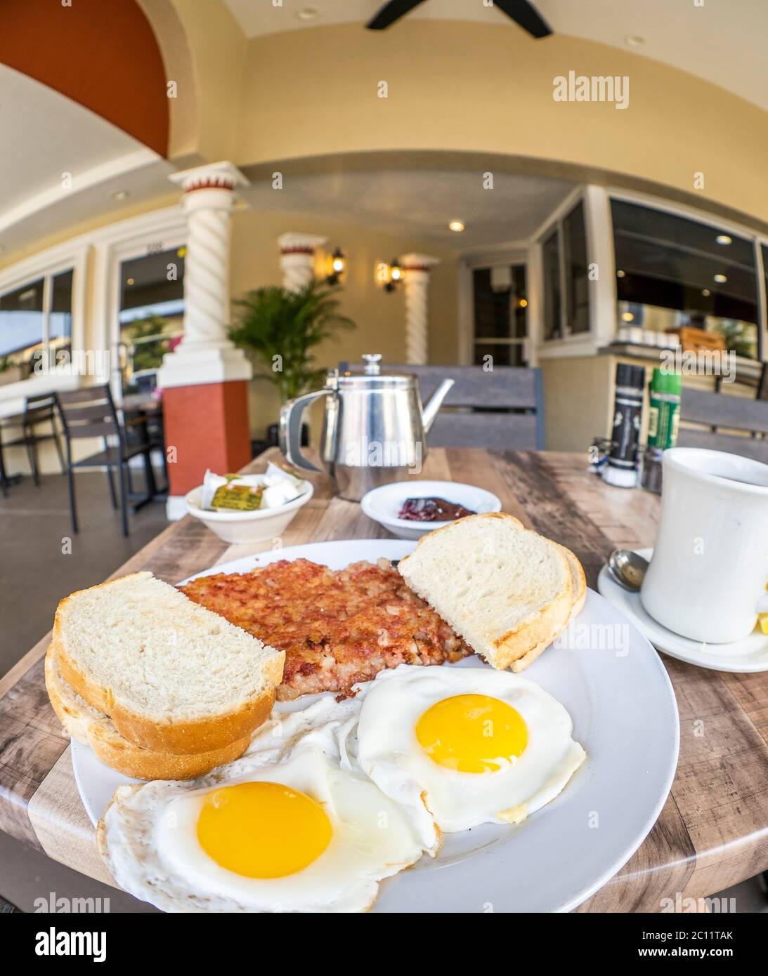 Nahaufnahme des Frühstücksplattes mit Rinderhasch, Eiern und Toast mit Fischaugenobjektiv Stockfoto