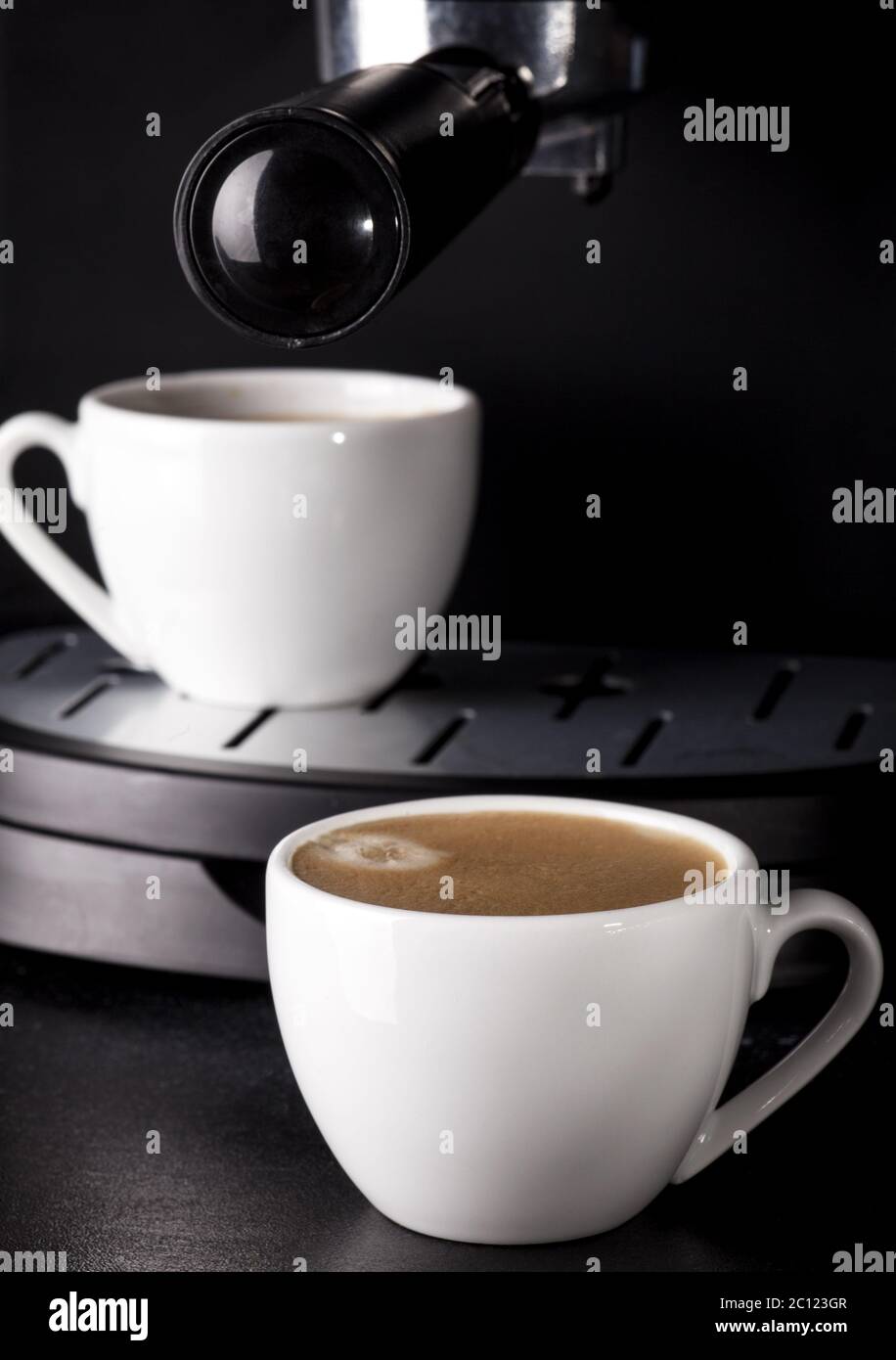 Espresso-Tassen und Kaffee aus dem Automaten. Stockfoto