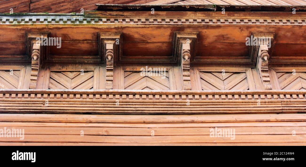 Kunstliche Dekor-Trimm und klassische alte Holzhaus. Dreieckige Muster Holz Textur Ziegelfarbe. Stockfoto