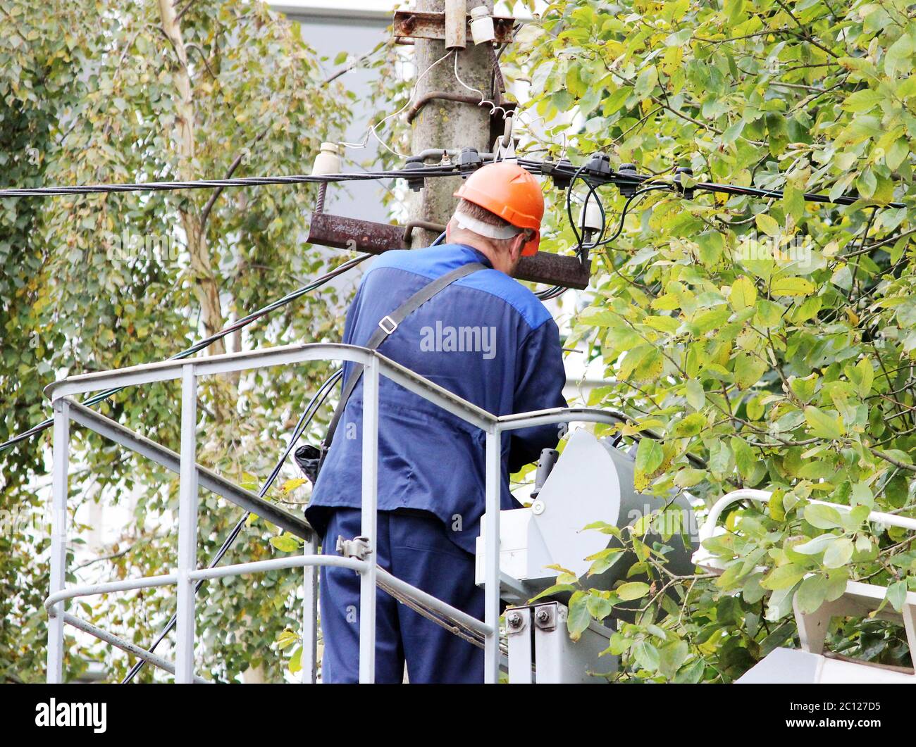 Elektrischen Arbeiter die Drähte an den Mast mit Hilfe des Fahrkorbes zu reparieren. Stockfoto