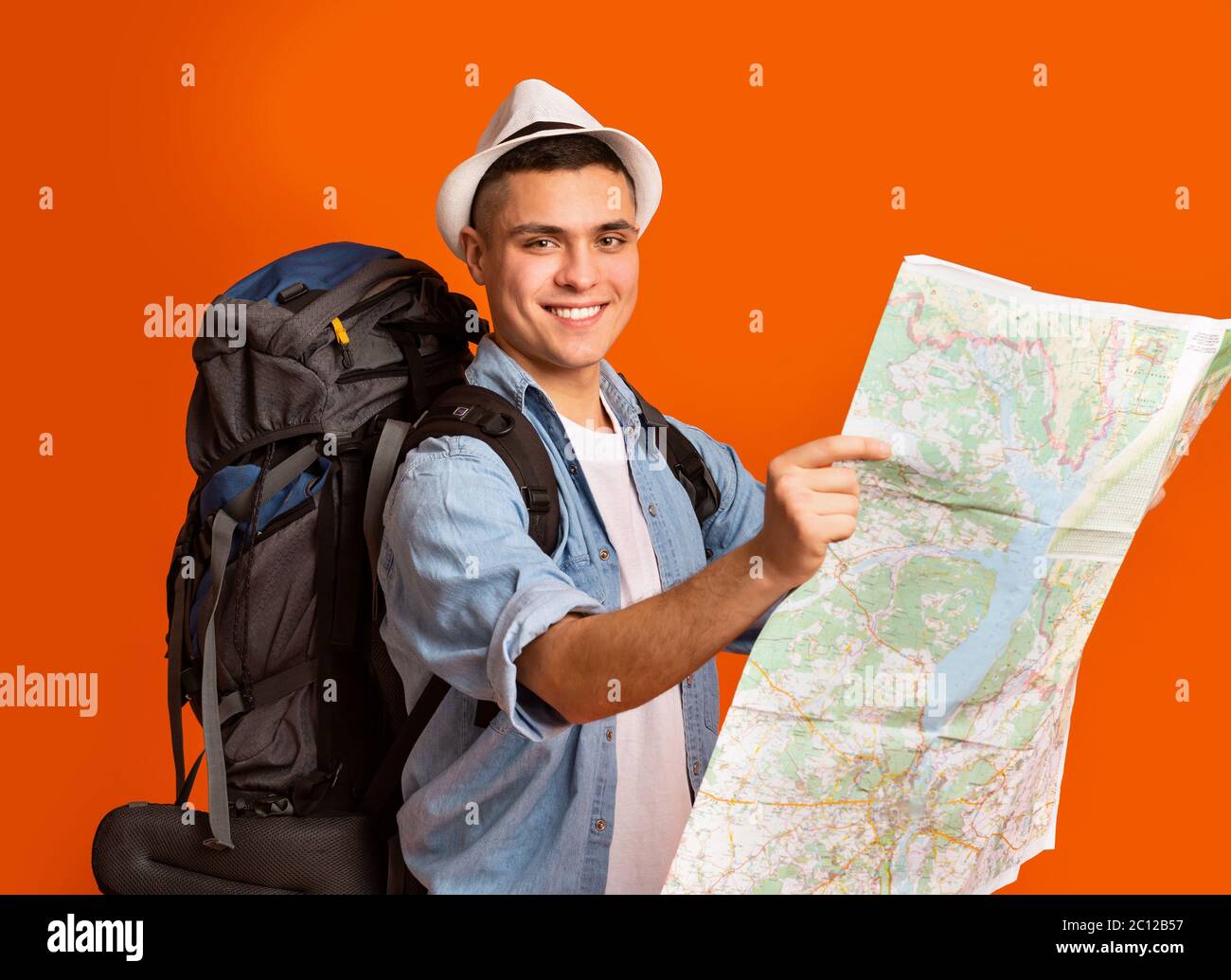 Aktiver Wanderer mit großem Rucksack auf der Karte Stockfoto