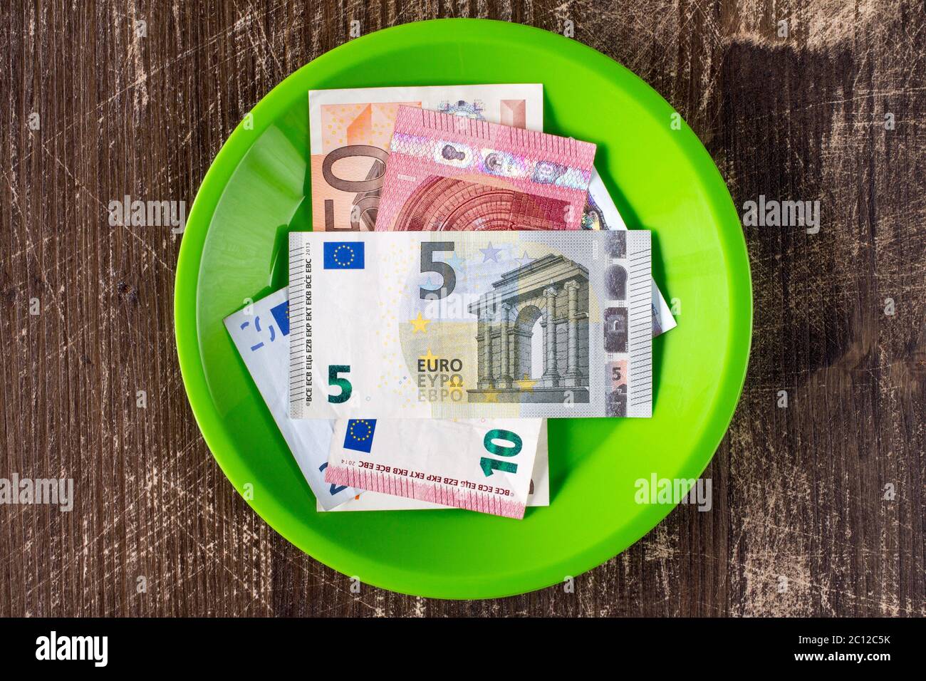 Grüner Teller mit Euro-Noten. Stockfoto