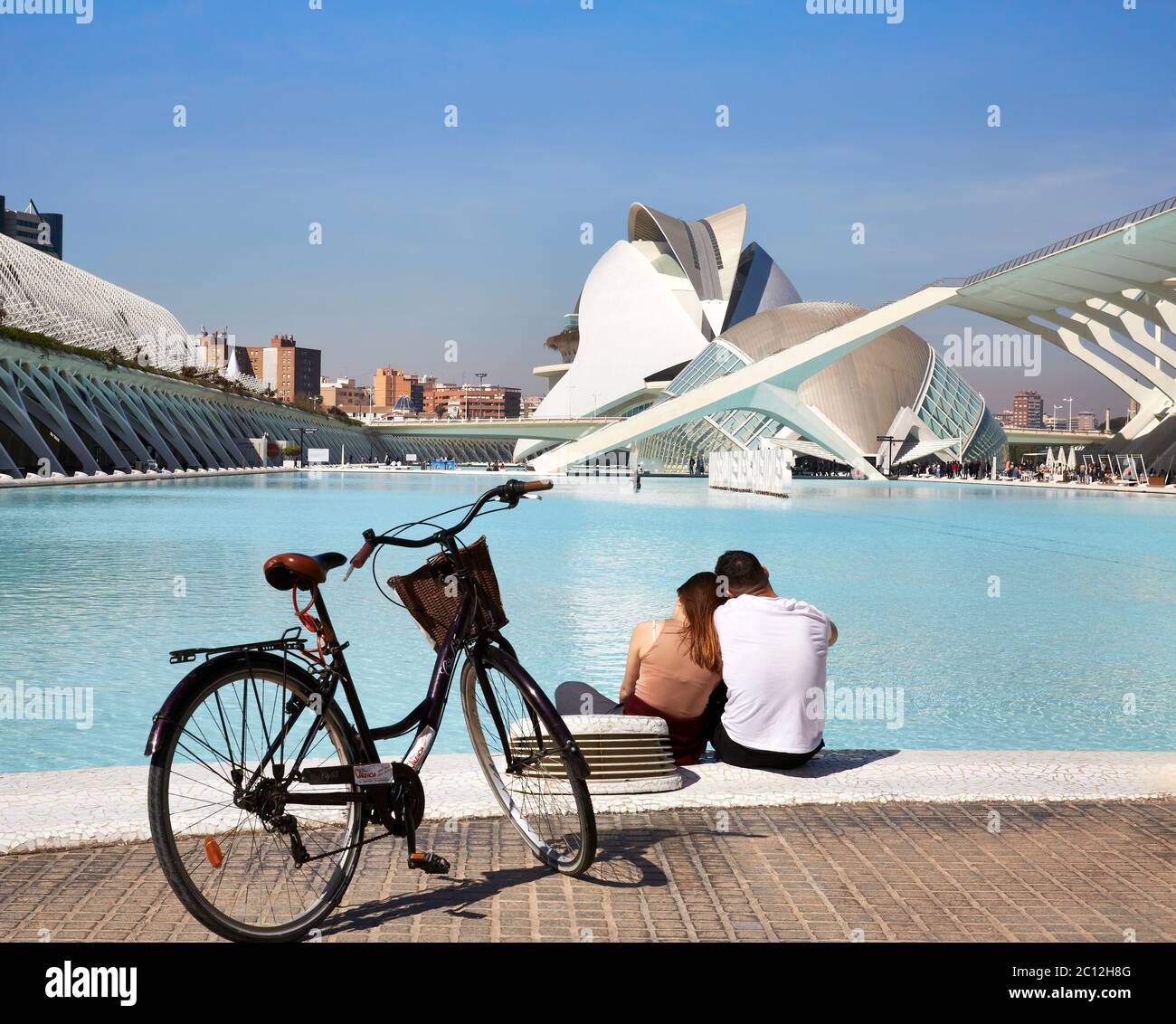 Junges Paar, das am Pool im Science Park in valencia, Spanien sitzt. Stockfoto