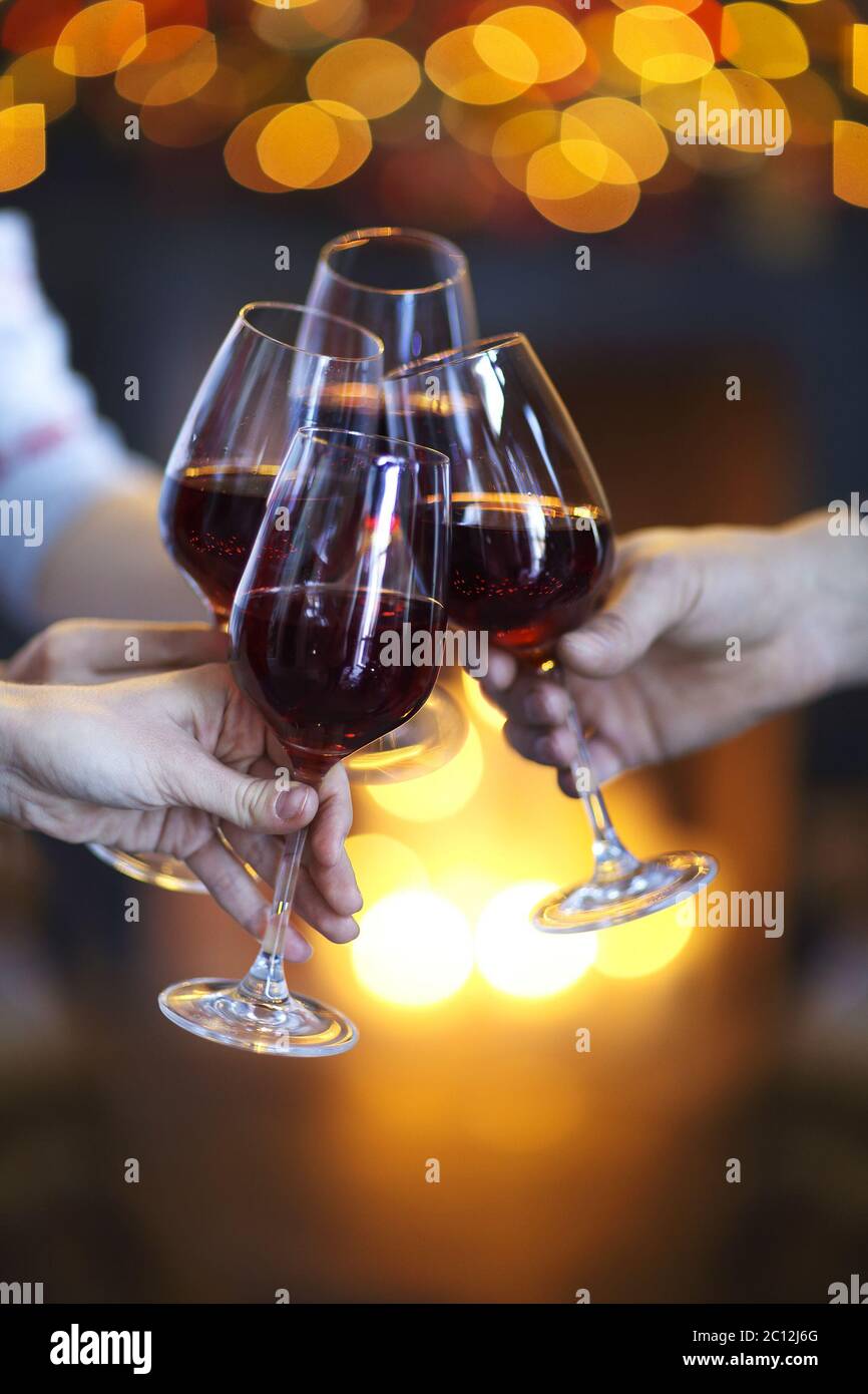 Klirrende Gläser Wein in den Händen auf hellen Lichtern Hintergrund Stockfoto