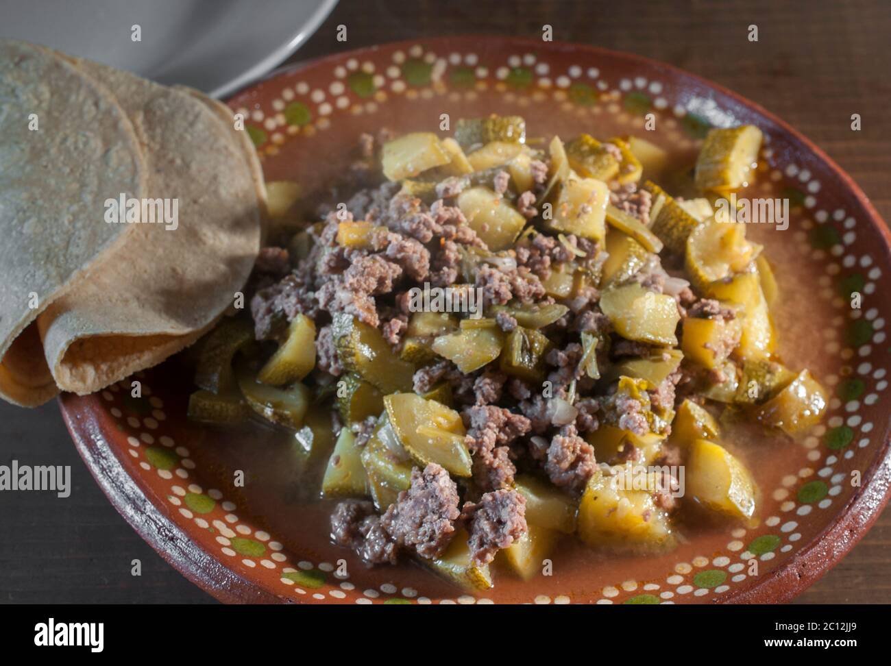 Nahaufnahme Bild der traditionellen mexikanischen Küche, Rindfleisch oder Fleisch PICADILLO mit Zucchini Zwiebeln und Paprika mit Tortillas auf der Seite Stockfoto