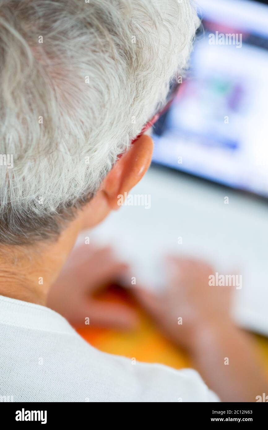 Alte Person in Brille beschäftigt mit einem Laptop arbeiten Stockfoto