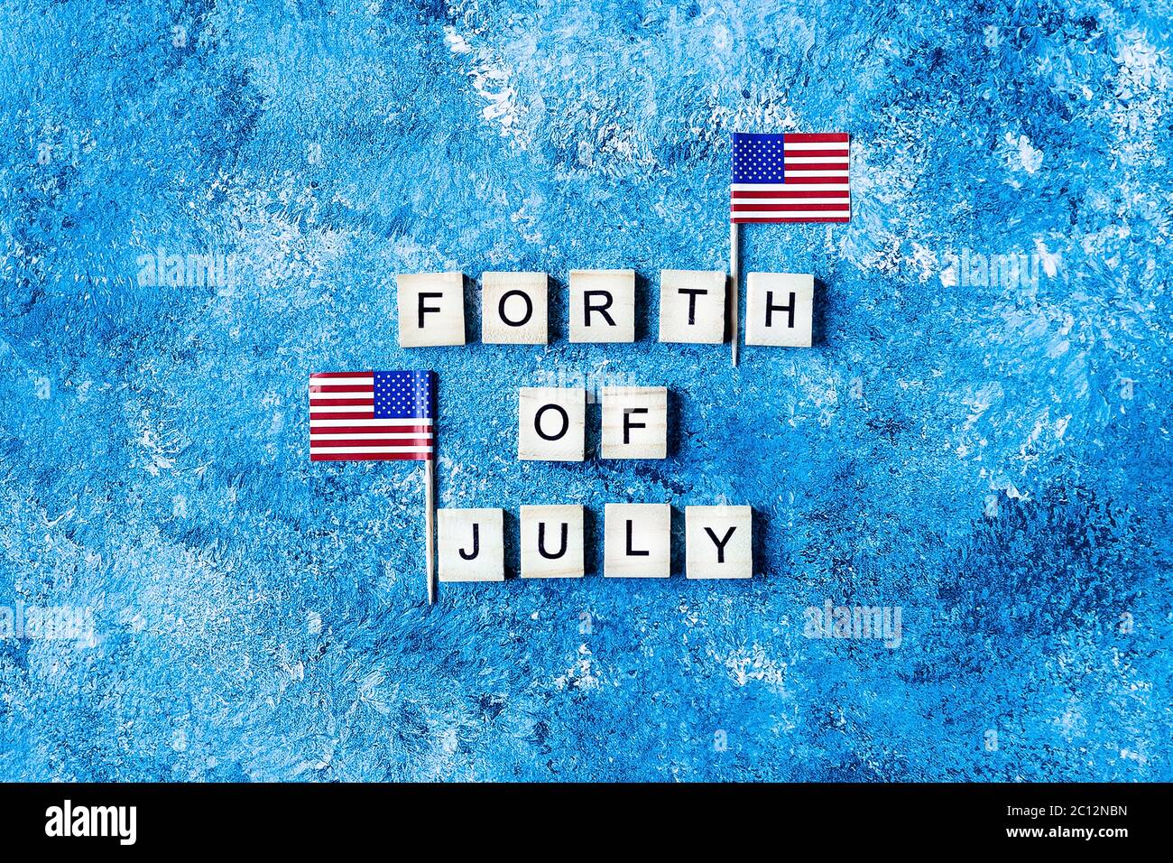 Die Inschrift Juli 4 in Holzbuchstaben auf blauem Hintergrund. Entwurf der Inschrift zum amerikanischen Unabhängigkeitstag. Hintergrundvorlage für Greeti Stockfoto