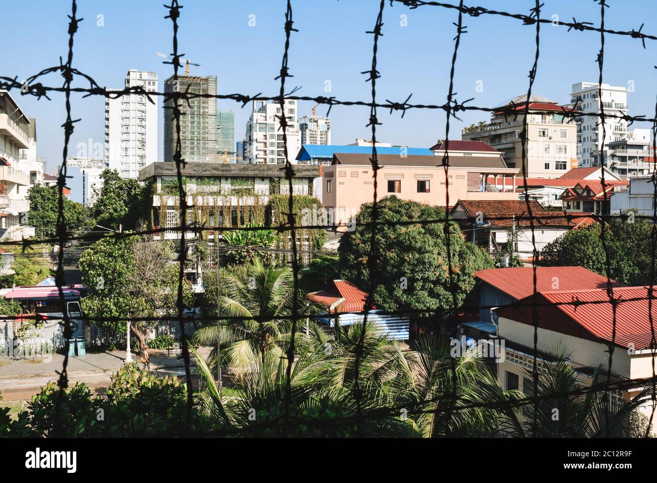 Blick auf Phnom Penh durch Stacheldrahtzaun vom S21 Tuol Sleng Genozid Museum Phnom Penh Kambodscha Stockfoto