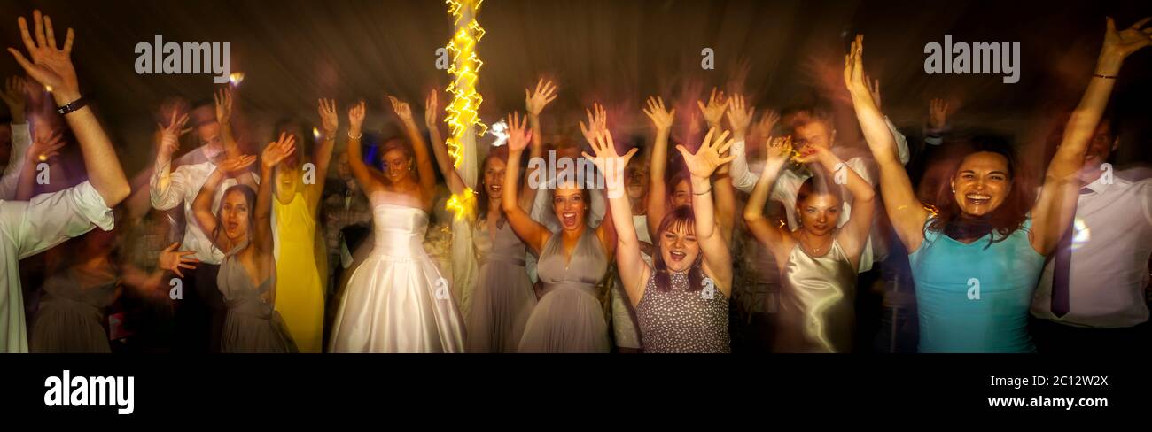 Hände hoch für ein Gruppenfoto auf der Tanzfläche. Britische Hochzeit in South Cambridgeshire, England Stockfoto