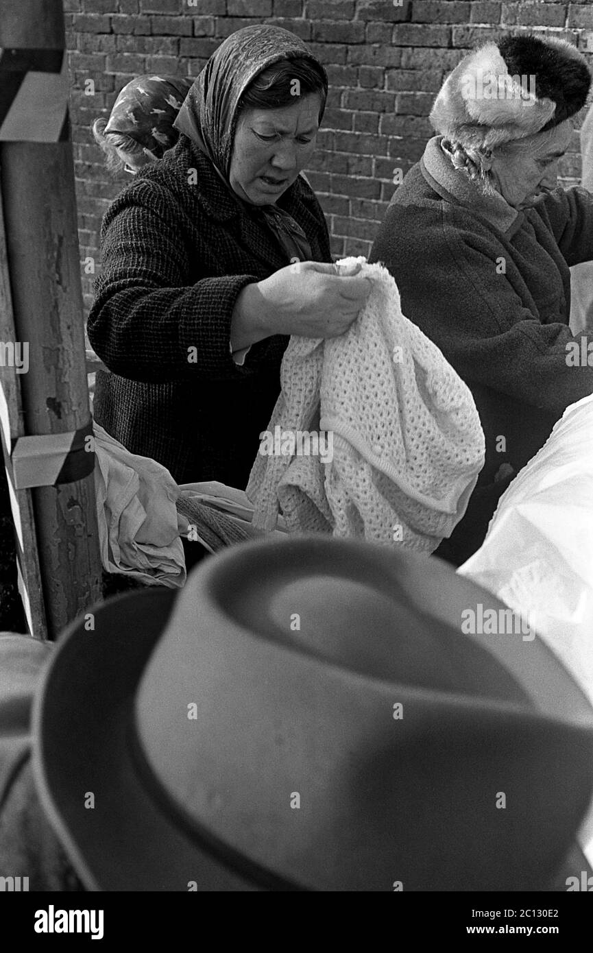 AJAXNETPHOTO. FEBRUAR 1975. PORTSMOUTH, ENGLAND. - FLOHMARKT - IN DER UNICORN ROAD; KÄUFER STÖBERN DURCH GEBRAUCHTE WAREN UND KLEIDUNG AUF DEM BÜRGERSTEIG.FOTO:JONATHAN EASTLAND/AJAX REF:7513 31A 115 Stockfoto