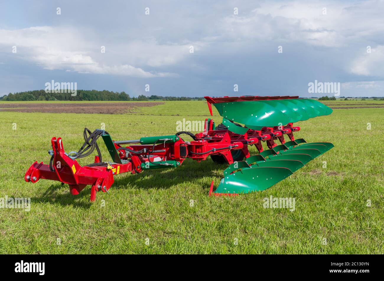 Der moderne Traktor Pflug auf dem Rasen platziert Stockfoto