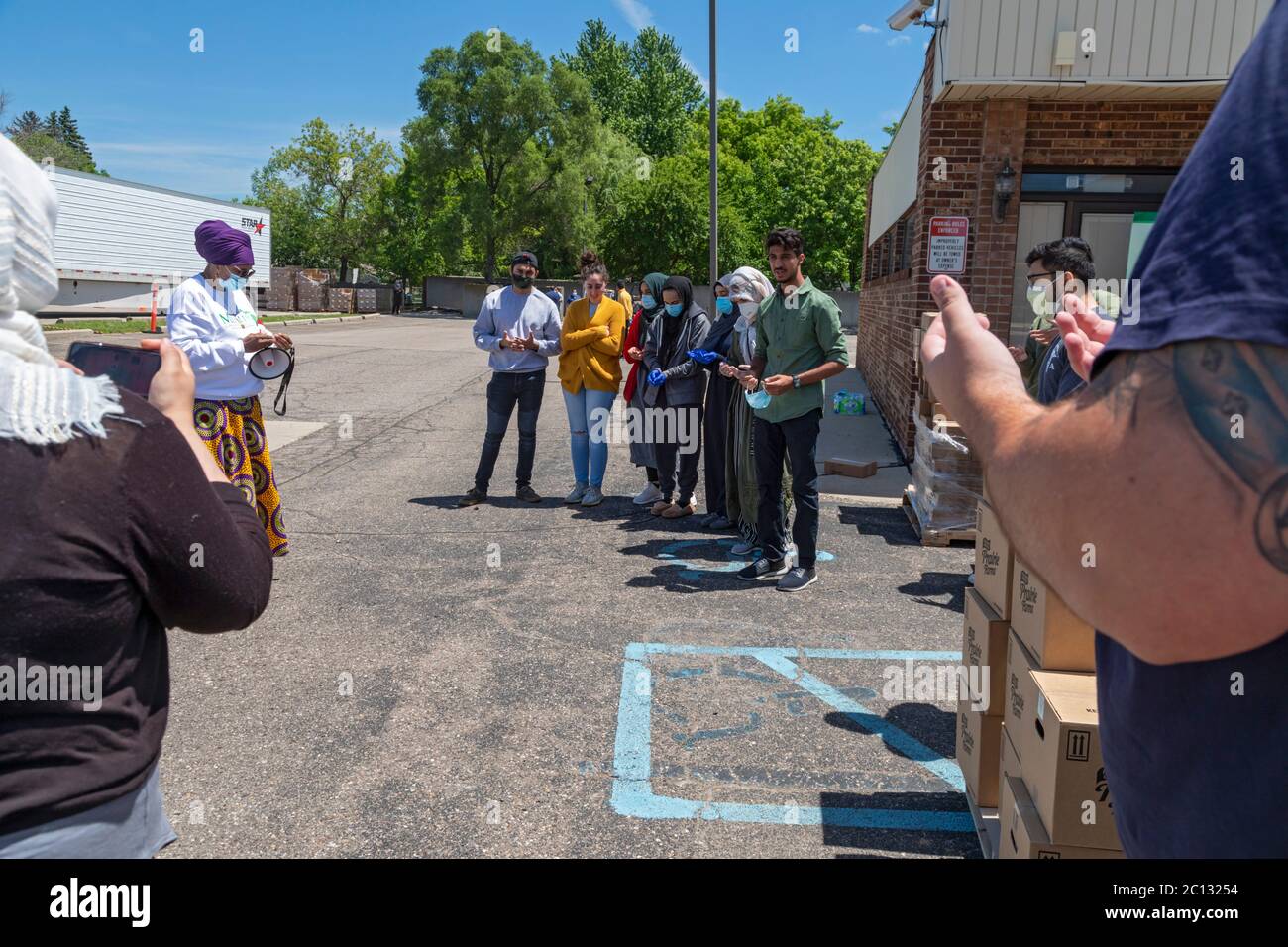 Warren, Michigan, USA. Juni 2020. Muslime beten, bevor sie während der Coronavirus-Pandemie an die Gemeindemitglieder Lebensmittel verteilen. Der Michigan Muslim Community Council verteilte Kästen mit Milchprodukten und frischen Produkten an alle Bedürftigen. Quelle: Jim West/Alamy Live News Stockfoto