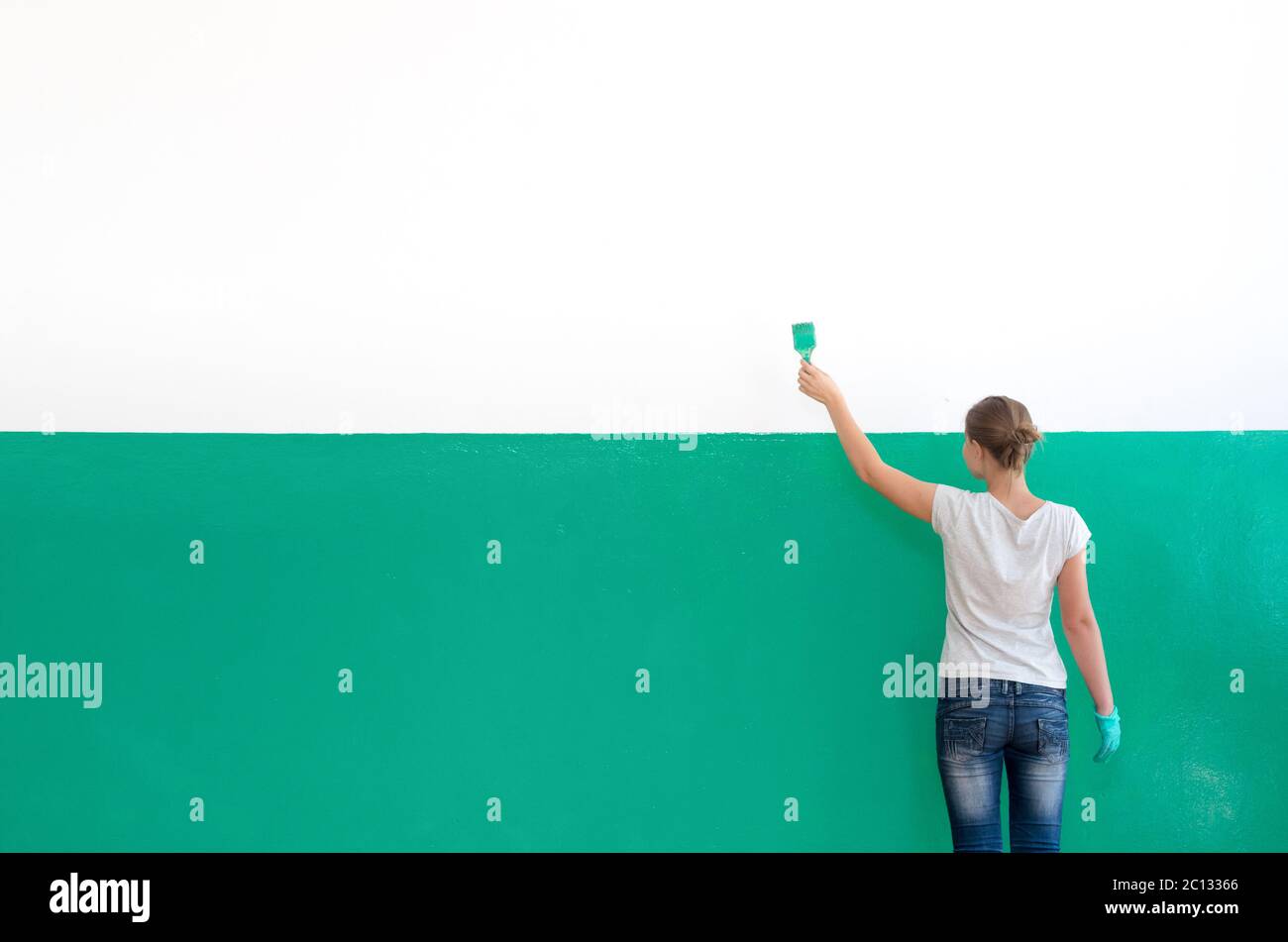 An der Wand stehen Mädchen mit Pinsel Stockfoto