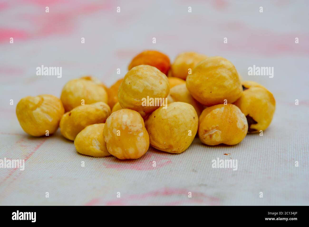 Eine Handvoll Haselnüsse auf einem Tisch. Schöne reife Nüsse von cremiger Farbe, Bernstein wie glatte Kastanien als Lebensmittelzutat für köstliche recipi verarbeiten Stockfoto