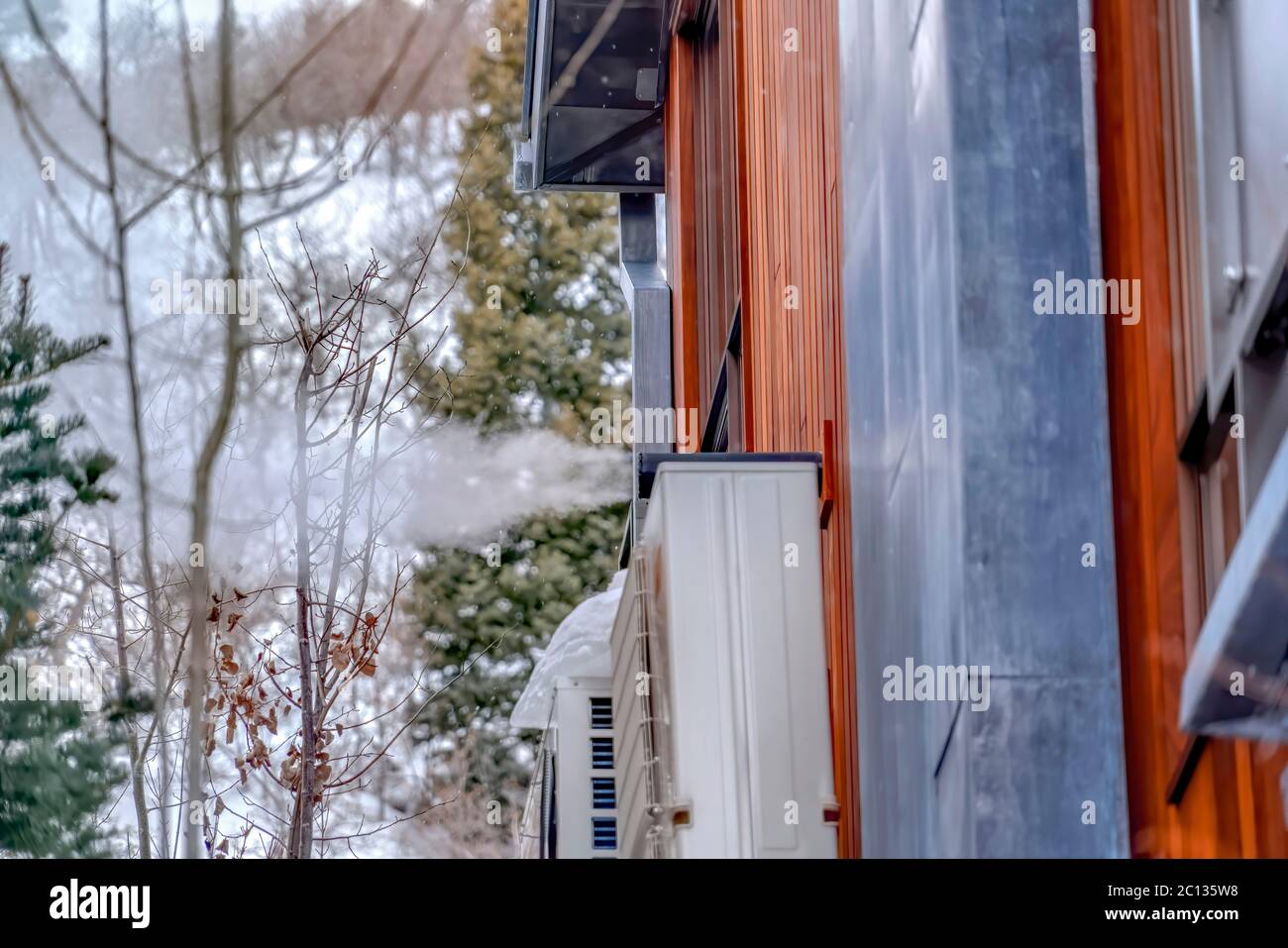 Außenwand des Hauses mit Klimaanlagen und Rohr, das Dampf abbläst Stockfoto