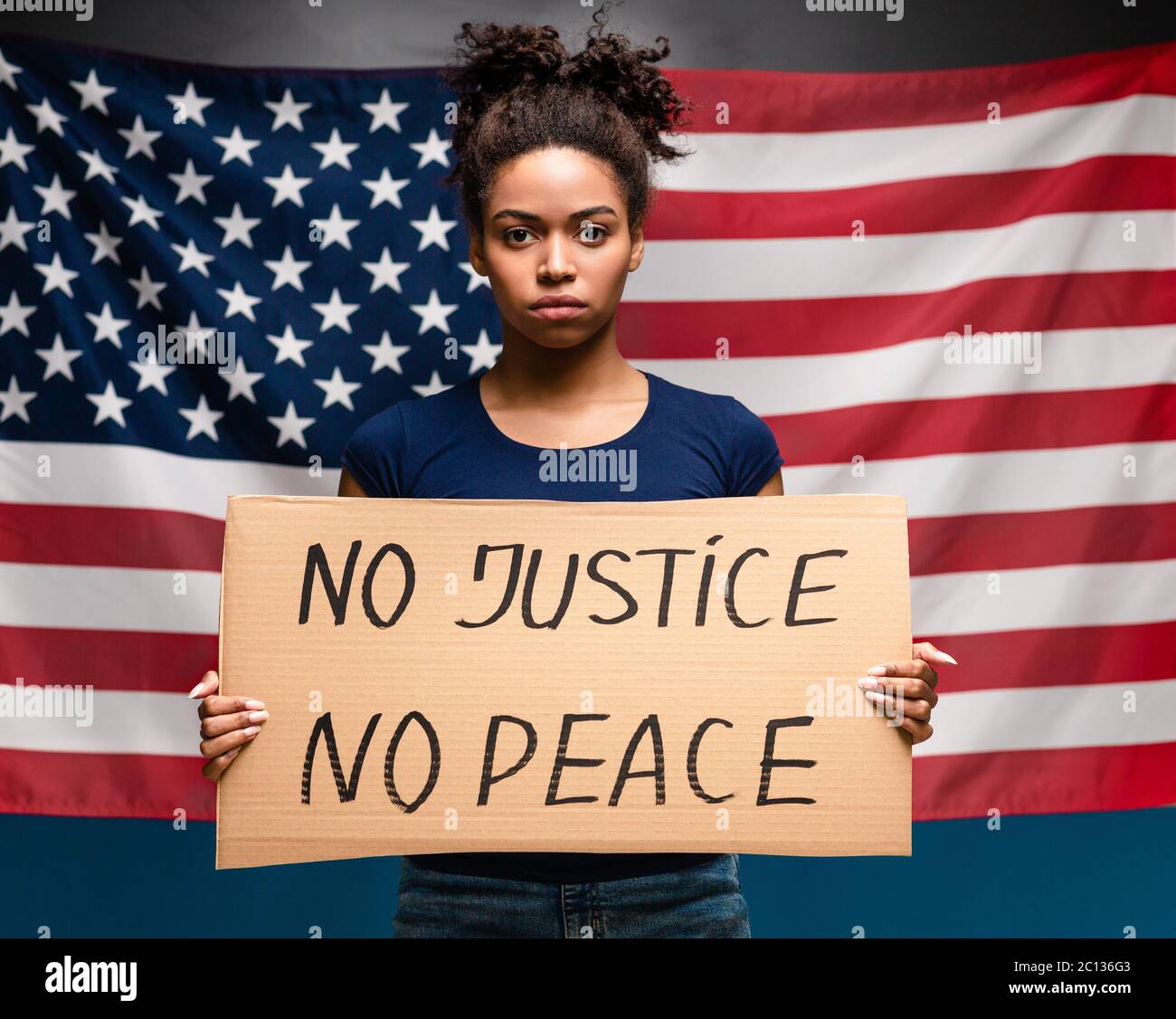 Serious afroamerikanische Mädchen mit Plakat No Peace No Justice Stockfoto
