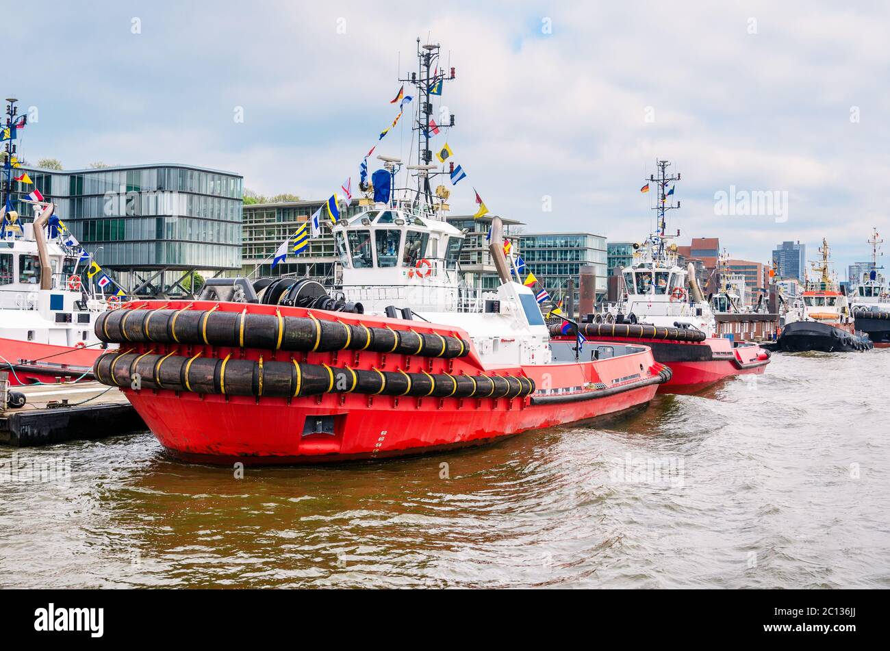 Leistungsstarke Schlepper, die an einem Steg in einem Flusshafen festgemacht haben. Hamburg, Deutschland Stockfoto