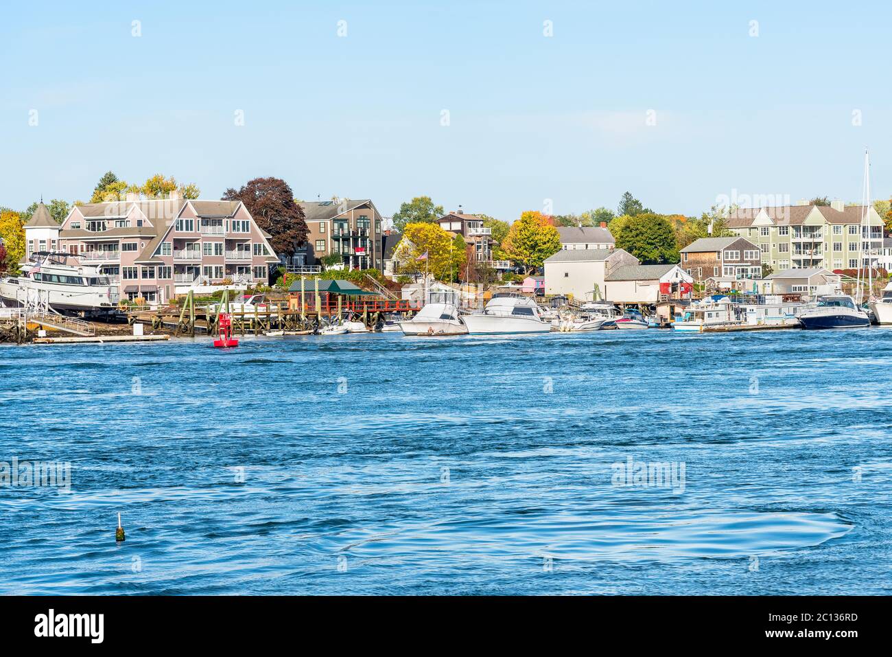 Hafen entlang eines großen Flusses mit Wohngebäuden im Hintergrund an einem klaren Herbsttag Stockfoto