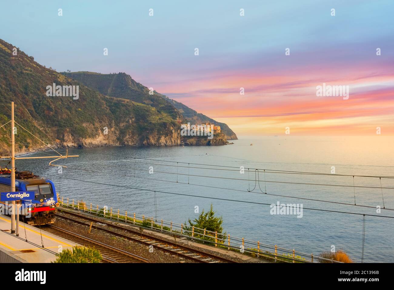 Sonnenuntergang auf der Cinque Terre, während der Zug in den Bahnhof Corniglia an der Küste Italiens fährt Stockfoto