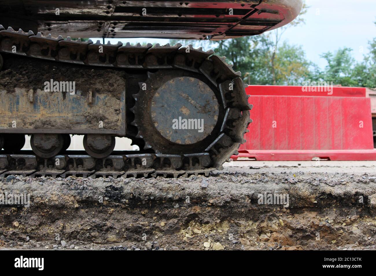 Große Raupe des Baggers auf dem Hintergrund Kunststoffgehäuse. Stockfoto